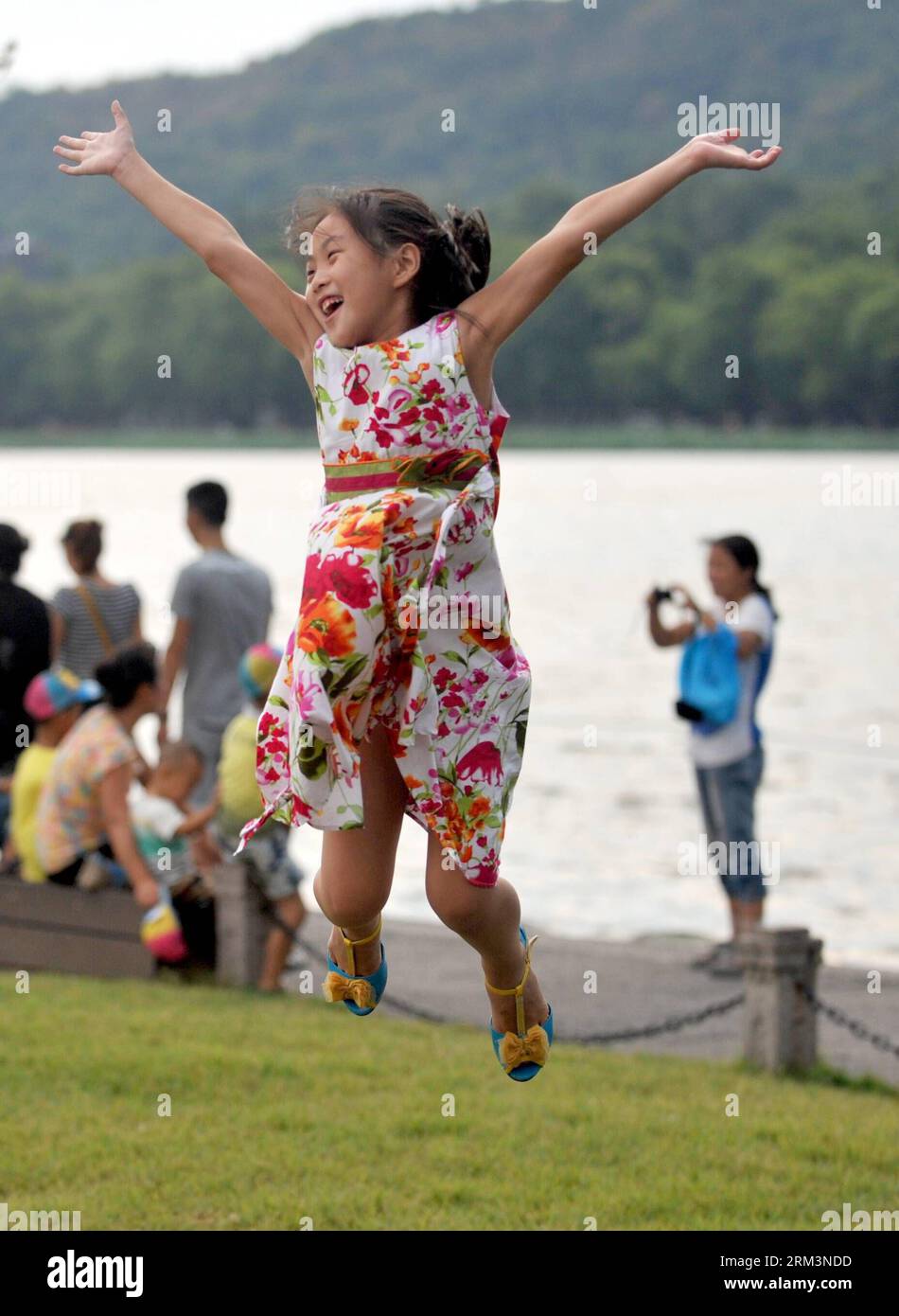 Bildnummer: 60260022 Datum: 31.07.2013 Copyright: imago/Xinhua (130731) -- HANGZHOU, 31. Juli 2013 (Xinhua) -- Ein kleines Mädchen genießt sich auf dem Baidi Causeway am Westsee in Hangzhou, der Hauptstadt der ostchinesischen Provinz Zhejiang, 31. Juli 2013. Ein Donnersturm am Mittwoch brachte kühle Luft in Hangzhou, eine Stadt, die seit dem 24. Juli sechs Tage lang über 40 Grad Celsius erlebte. (Xinhua/Wang Dingchang)(wjq) CHINA-ZHEJIANG-HANGZHOU-THUNDER SHOWER (CN) PUBLICATIONxNOTxINxCHN Gesellschaft x2x xkg 2013 hoch premiumd o0 Kind freude mädchen springt optimistisch 60260022 Da Stockfoto