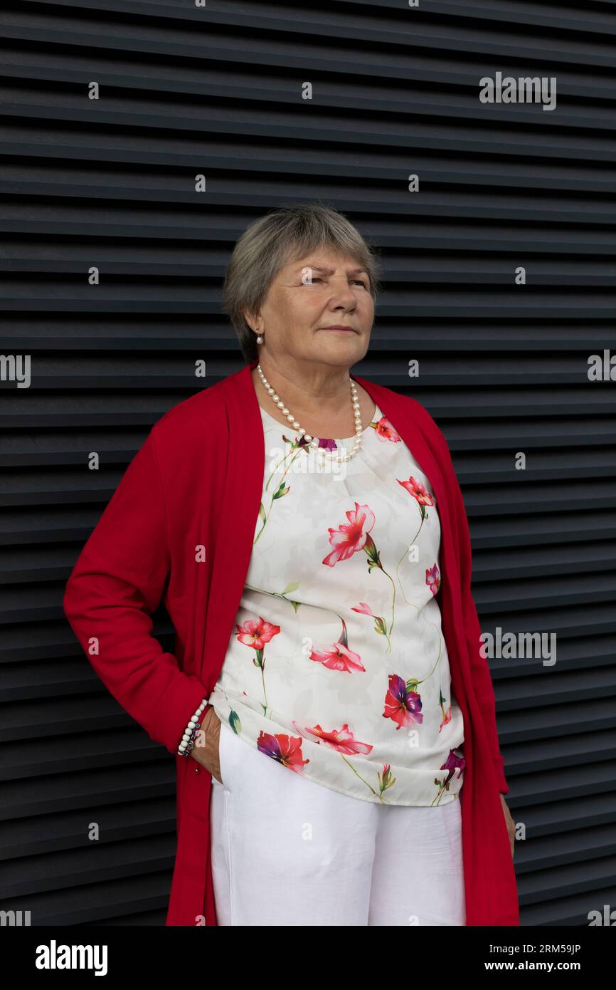Nahaufnahme Real Senior, alter 70s-jähriger Rentner, dunkle Wand im Hintergrund. Porträt Einer Entspannten Älteren Frau Im Freien, Copy Space For Text. Authentisch Stockfoto