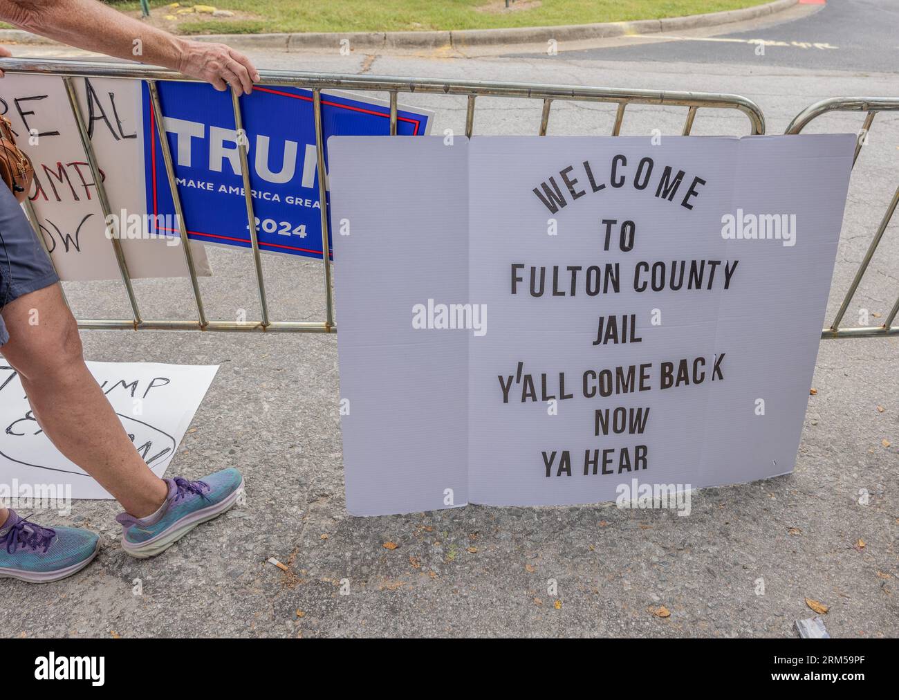 ATLANTA, Ga — 24. August 2023: In der Nähe des Gefängnisses von Fulton County sind vor der Buchung des ehemaligen Präsidenten Donald J. Trump Demonstrationsschilder zu sehen. Stockfoto