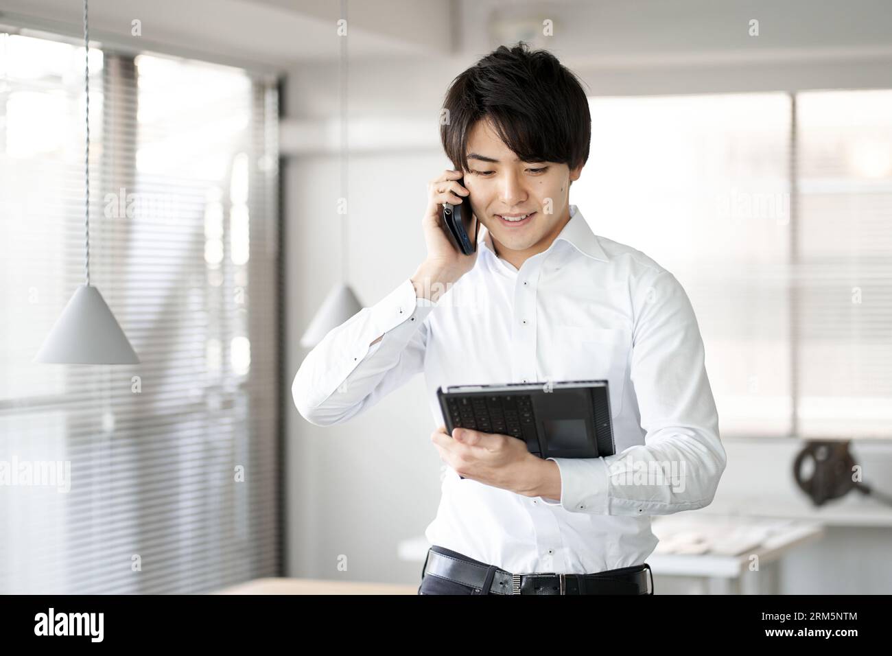 Asiatischer Mann, der im Büro telefoniert Stockfoto