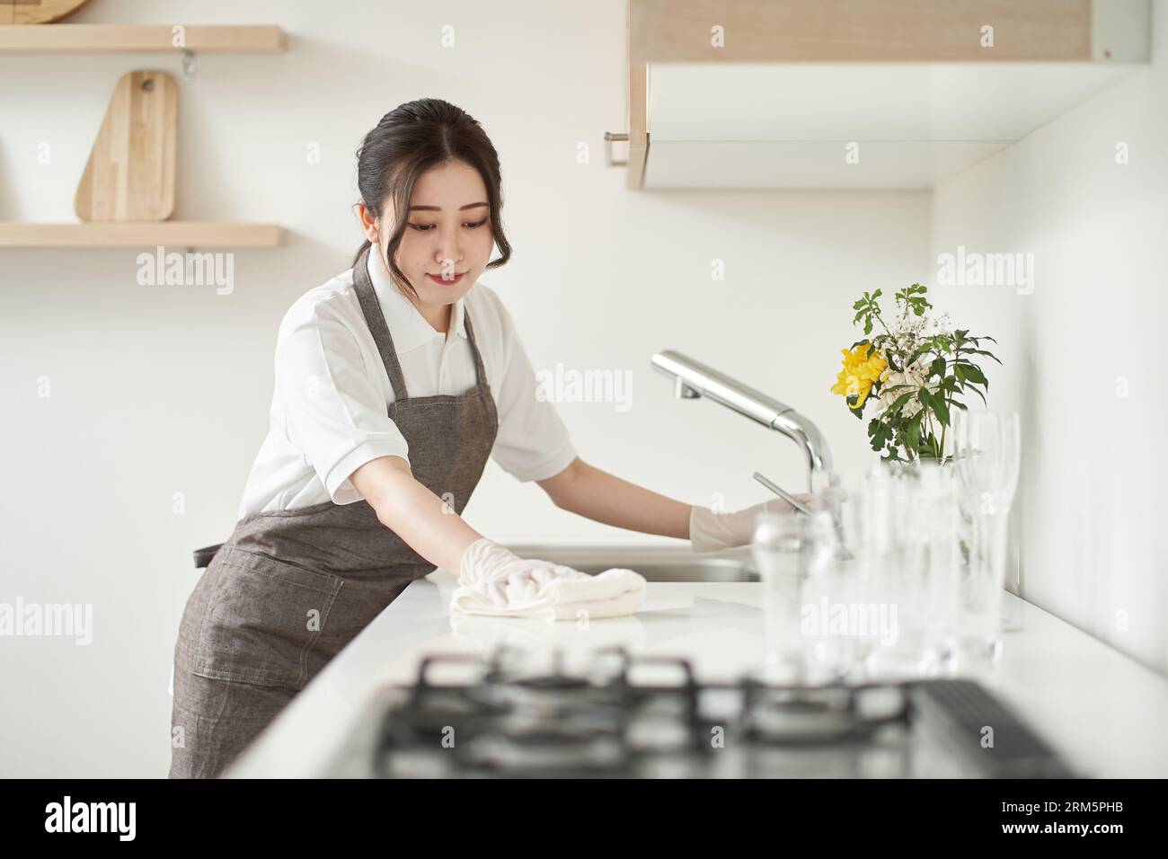 Asiatische Frau wischt die Küche ab Stockfoto