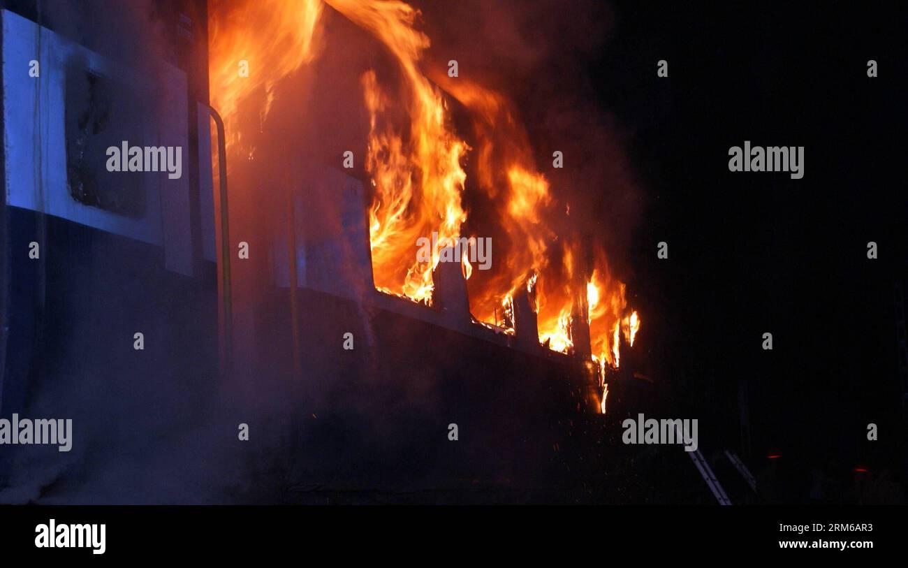 (131228) -- NEU DELHI, 28. Dezember 2013 (Xinhua) -- Kompartimente eines Bangalore-Nanded Express-Zuges werden in Flammen in der Nähe des Kothacheruvu-Bahnhofs bei Puttaparthi im indischen Bundesstaat Andhra Pradesh, 28. Dezember 2013, verwickelt. Mindestens 23 Menschen, darunter zwei Kinder, wurden zu Tode verbrannt und 12 weitere wurden bei einem Großbrand verletzt, der in einem klimatisierten Bus eines Schnellzuges im südindischen Bundesstaat Andhra Pradesh in den frühen Stunden des Samstags ausbrach, sagte ein hochrangiger Polizeibeamter. (Xinhua/Stringer) INDIA-PUTTAPARTHI-UNFALL-ZUGFEUER PUBLICATIONxNOTxINxCHN New Delhi DEC 28 2013 XINH Stockfoto