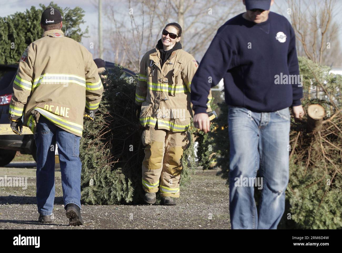 Ein Feuerwehrmann trägt einen weihnachtsbaum, der am 4. Januar 2014 im Garry Point Park in Richmond, Kanada, recycelt werden kann. Feuerwehrleute in Richmond veranstalteten die 32. Richmond Firefighters Charitable Society Drive-Thru-Veranstaltung, um der Gemeinde zu helfen, ihre weihnachtsbäume wiederzuverwerten und Geld für die lokale Lebensmittelbank zu sammeln. (Xinhua/Liang Sen) CANADA-VANCOUVER-CHRISTMAS TREES-RECYCLE PUBLICATIONxNOTxINxCHN ein Fire Fighter trägt einen Weihnachtsbaum zum Recycling IM Garry Point Park in Richmond Kanada 4. Januar 2014 Firefighters in Richmond Hero die 32. Richmond Firefighters Charitable Society Drive Through Event, um der zu helfen Stockfoto