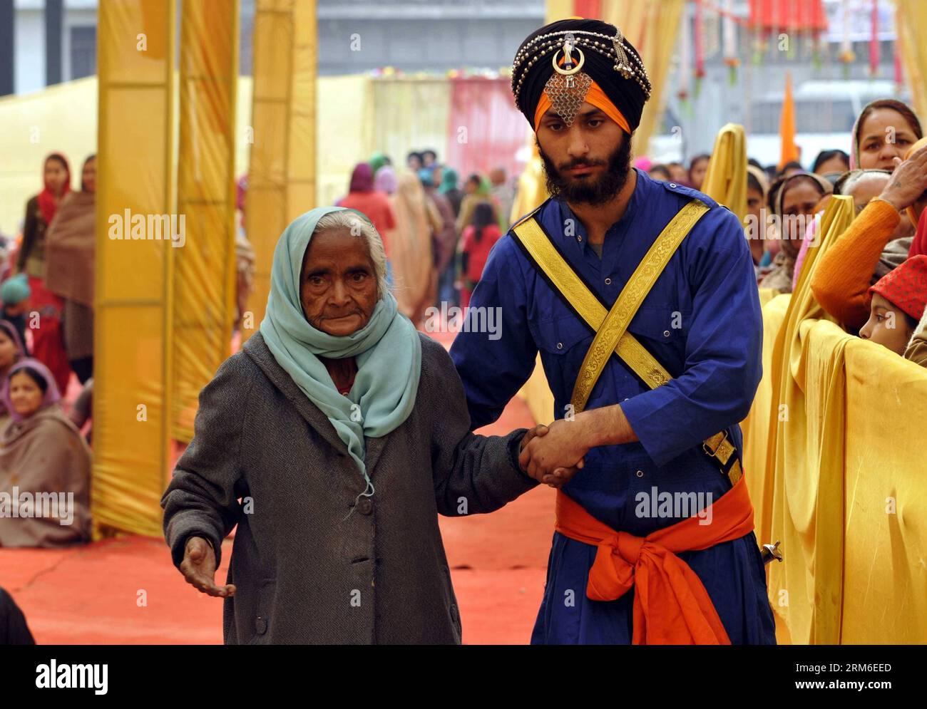 (140107) -- JAMMU, 7. Januar 2014. (Xinhua) -- Eine Sikh-Freiwillige hält die Hand einer alten sikh-Frau, als sie kommt, um zum Geburtstag des Sikh-Gurus Sri Guru Gobind Singh in Jammu, der Winterhauptstadt des von Indien kontrollierten Kaschmirs, am 7. Januar 2014 zu beten. Sikhs feierte Geburtstag von Guru Gobind Singh, dem zehnten und letzten Guru von Sikhs. (Xinhua/Stringer) KASHMIR-JAMMU-SIKH FESTIVAL PUBLICATIONxNOTxINxCHN JAMMU 7. Januar 2014 XINHUA A Sikh Volunteer hält die Hand einer alten Sikh-Frau, als sie KOMMT, um Gebete ZUM Geburtstag des Sikh Guru Sri Singh in Jammu ANZUBIETEN Stockfoto