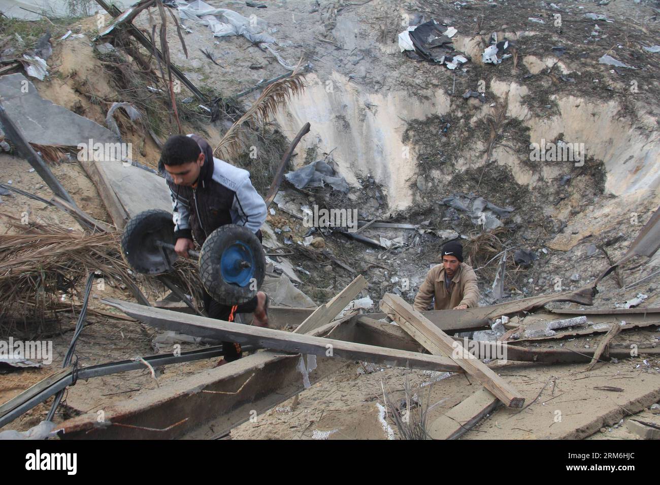 (140114) -- GAZA, 14. Januar 2014 (Xinhua) -- Ein Palästinenser inspiziert die Schäden in einem Trainingsgelände für die Al-Quds-Brigaden, dem militärischen Flügel der Islamischen Dschihad-Bewegung, in der Stadt Khan Yunis im südlichen Gazastreifen am 14. Januar 2014. Die israelische Luftwaffe Griff am Montagabend militante Ziele im Gazastreifen an, als Reaktion auf Raketenbeschüsse aus dem palästinensischen Gebiet auf Südisrael den ganzen Tag über, sagten die israelischen Verteidigungskräfte (IDF). (Xinhua/Khaled Omar) MIDEAST-GAZA-LUFTANGRIFF PUBLICATIONxNOTxINxCHN Gaza 14. Januar 2014 XINHUA ein PALÄSTINENSER inspiziert die Schäden in einem Training S Stockfoto