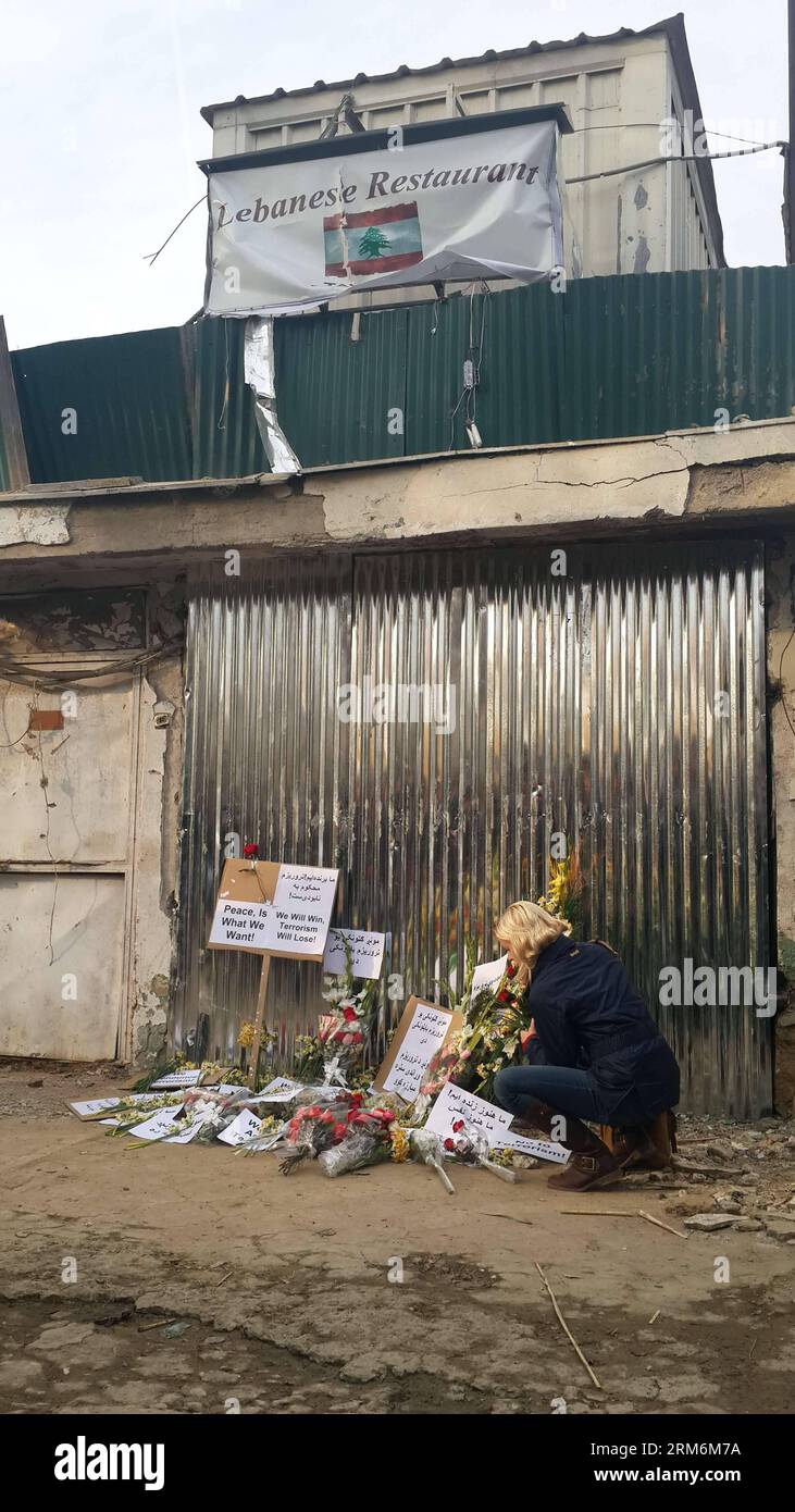 (140119) -- KABUL, 19. Januar 2014 (Xinhua) -- Eine Frau legt am 19. Januar 2014 Blumen vor dem Eingangstor des libanesischen Restaurants in Kabul, der Hauptstadt Afghanistans. Ein Selbstmordanschlag der Taliban auf ein libanesisches Restaurant, das bei Ausländern beliebt ist, am Freitagabend in dem befestigten Teil der afghanischen Hauptstadt, bei dem 21 Menschen, darunter 13 Ausländer, getötet wurden, hat die Befürchtungen, dass sich eine irakische Situation in Afghanistan wiederholen könnte, nachdem die von den USA geführten Koalitionstruppen den Konflikt verlassen haben, wieder aufleben lassen Land bis zum Jahresende (Xinhua/Zhao Yishen) AFGHANISTAN-KABUL-ATTENTAT-TRAUER PUBLICATIONxNOTxINxCH Stockfoto