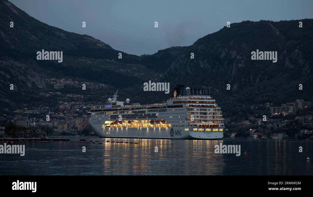 Kotor, Montenegro, 16. April 2023: Kreuzfahrtschiff MSC ARMONIA vor Anker in der Bucht von Kotor in der Abenddämmerung Stockfoto