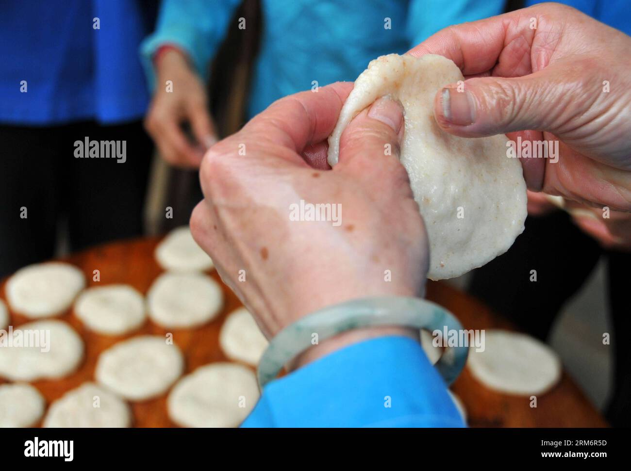 (140126) -- FUCHUAN, 26. Januar 2014 (Xinhua) -- Eine Frau aus der ethnischen Gruppe der Yao macht ciba, einen speziellen glutenfreien Reiskuchen, im Dorf Luoshan, Lianshan Township, Fuchuan Yao Autonomous County, südchinesische autonome Region Guangxi Zhuang, 26. Januar 2014. Die Yao-Leute in Fuchuan haben die Tradition, ciba für das Frühlingsfest und die Erntefeier zu machen. (Xinhua/Chen Zixia) (hdt) CHINA-FUCHUAN-CIBA (CN) PUBLICATIONxNOTxINxCHN Fuchuan Jan 26 2014 XINHUA eine Frau aus der ethnischen Gruppe der Yao macht Ciba zu einem besonderen klebrigen Reiskuchen im Dorf Township Fuchuan Yao Autonomous County South China S Guangx Stockfoto