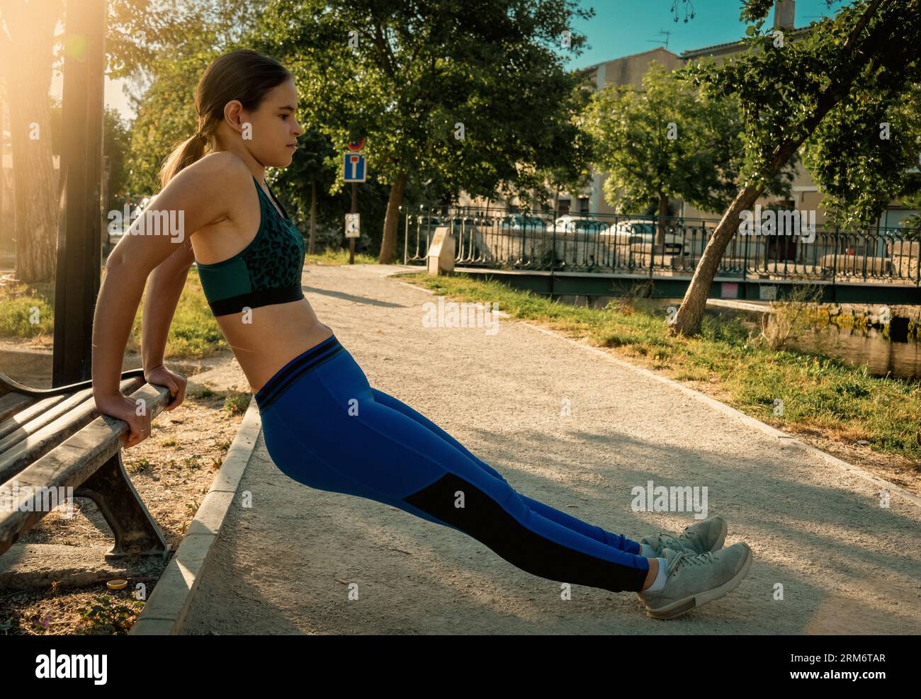 Schöne junge Frau, die sich aufwärmt oder im Morgenlicht trainiert, Sportlerin aktiver Lebensstil Stockfoto