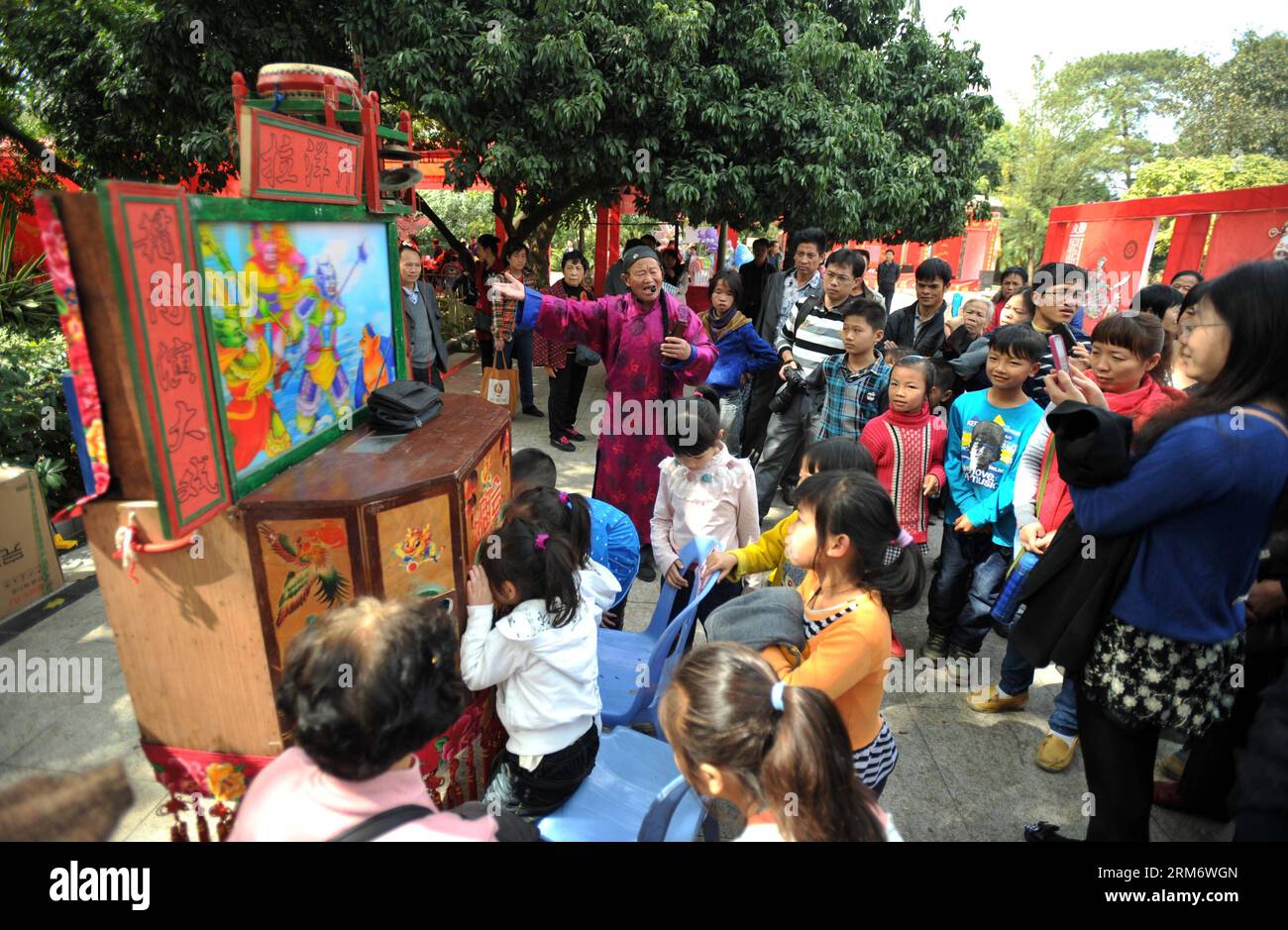 (140201) -- NANNING, 1. Februar 2014 (Xinhua) -- Ein Volkskünstler zeigt Eine Raree-Show auf einer Tempelmesse, um das Frühlingsfest oder das chinesische Mondneujahr in Nanning, der Hauptstadt der südchinesischen autonomen Region Guangxi Zhuang, 1. Februar 2014 zu feiern. Immaterielle Kulturgüter wie Schattenspiele und Papierschnitte zogen am Samstag, dem zweiten Tag der siebentägigen Pause zum Frühlingsfest, viele Menschen auf die Tempelmesse. (Xinhua/Lu Boan) (wjq) CHINA-NANNING-TEMPLE FAIR (CN) PUBLICATIONxNOTxINxCHN Nanning 1. Februar 2014 XINHUA ein Volkskünstler zeigt Show AT a Temple Fair, um die Spri zu feiern Stockfoto