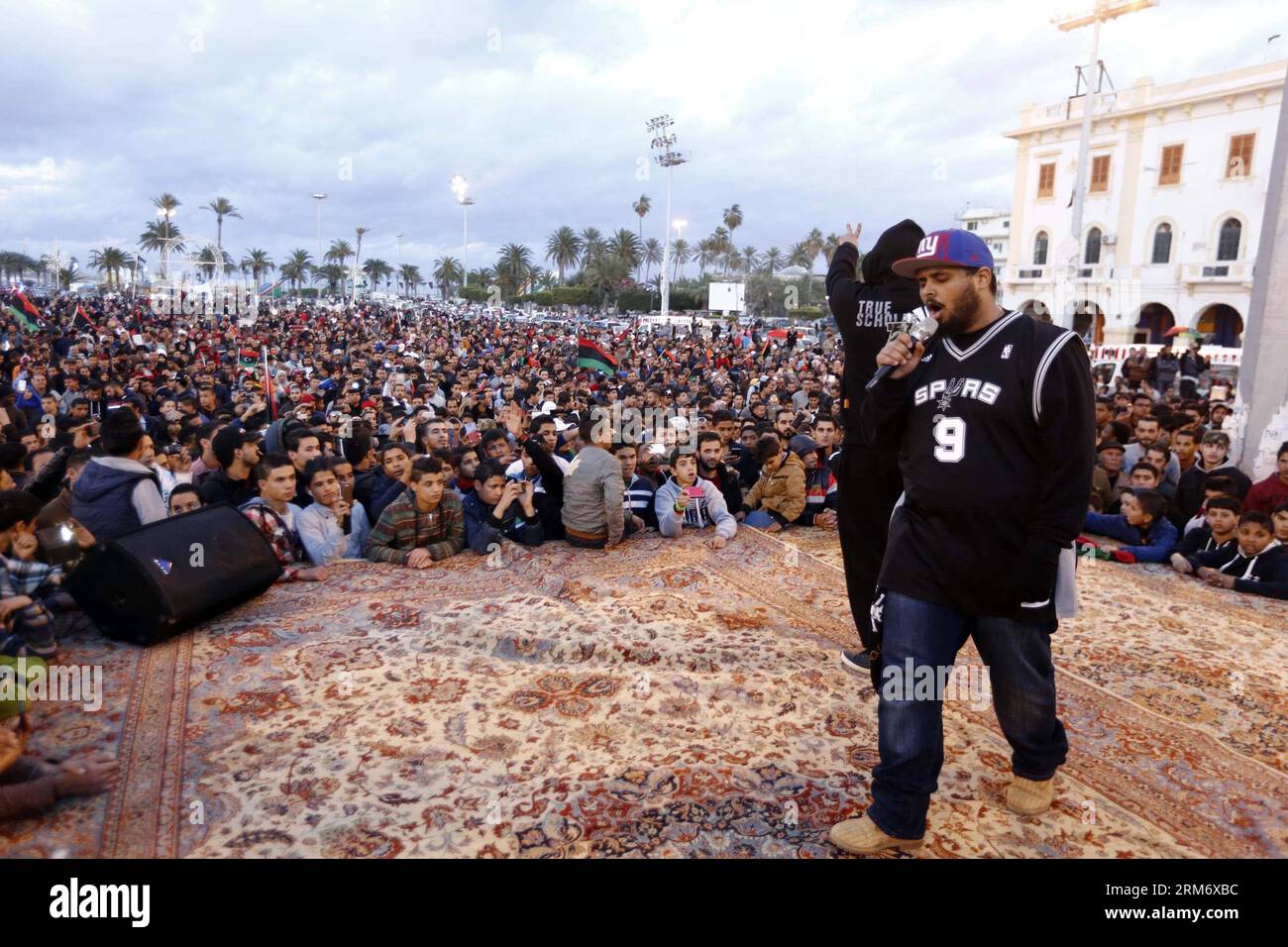 (140202) -- TRIPOLI, 2. Februar 2014 (Xinhua) -- Libyer genießen die Aufführung von Rap-Künstlern auf dem Märtyrerplatz, um den Sieg ihrer Fußballmannschaft bei der Afrikanischen Nationenmeisterschaft in der libyschen Hauptstadt Tripoli, 2. Februar 2014, zu feiern. Libyen gewann seinen ersten internationalen Fußballtitel, indem es Ghana im Finale der Afrikanischen Nationen-Meisterschaft am Samstag im Kapstadt-Stadion in Elfmeterschießen besiegte. (Xinhua/Hamza Turkia) LIBYEN-TRIPOLI-AFRICAN NATIONS CHAMPIONSHIP-CELEBRATIONS PUBLICATIONxNOTxINxCHN Tripoli 2. Februar 2014 XINHUA Genießen Sie die Vorstellung von Rap-Künstlern AUF DEM Märtyrerplatz, um den Sieg seiner so zu feiern Stockfoto