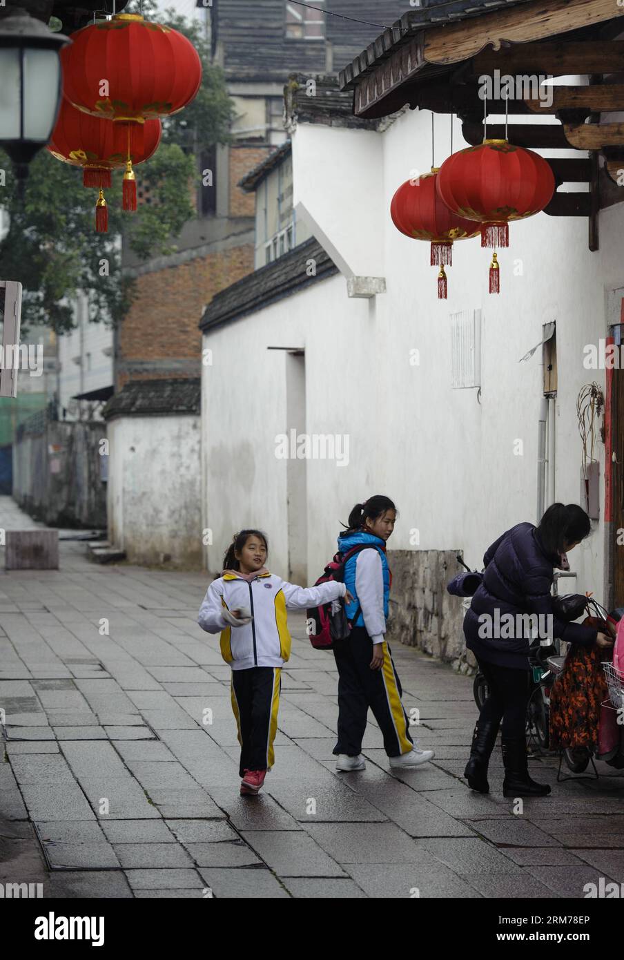 Ein Schüler (L) tanzt in den alten Gassen Three Lanes und Seven Alleys in Fuzhou, der Hauptstadt der südöstlichen chinesischen Provinz Fujian, am 18. Februar 2014. Viele Leute kamen hierher, um die Aussicht auf drei Lanes und sieben Gassen bei nebelndem Regen zu genießen. (Xinhua/Jiang Kehong) (af) CHINA-FUZHOU-TRAVEL(CN) PUBLICATIONxNOTxINxCHN ein Schüler tanzt in der Antike genannt drei Bahnen und Sieben in Fuzhou Hauptstadt von Südostchina S Fujian Provinz 18. Februar 2014 VIELE Prominente kamen hierher, um die Aussicht auf drei Bahnen und Sieben in Nebelrinen XINHUA Jiang Kehong AF China Fuzhou zu genießen Reise CN Verpackung xNOTxINxCHN Stockfoto
