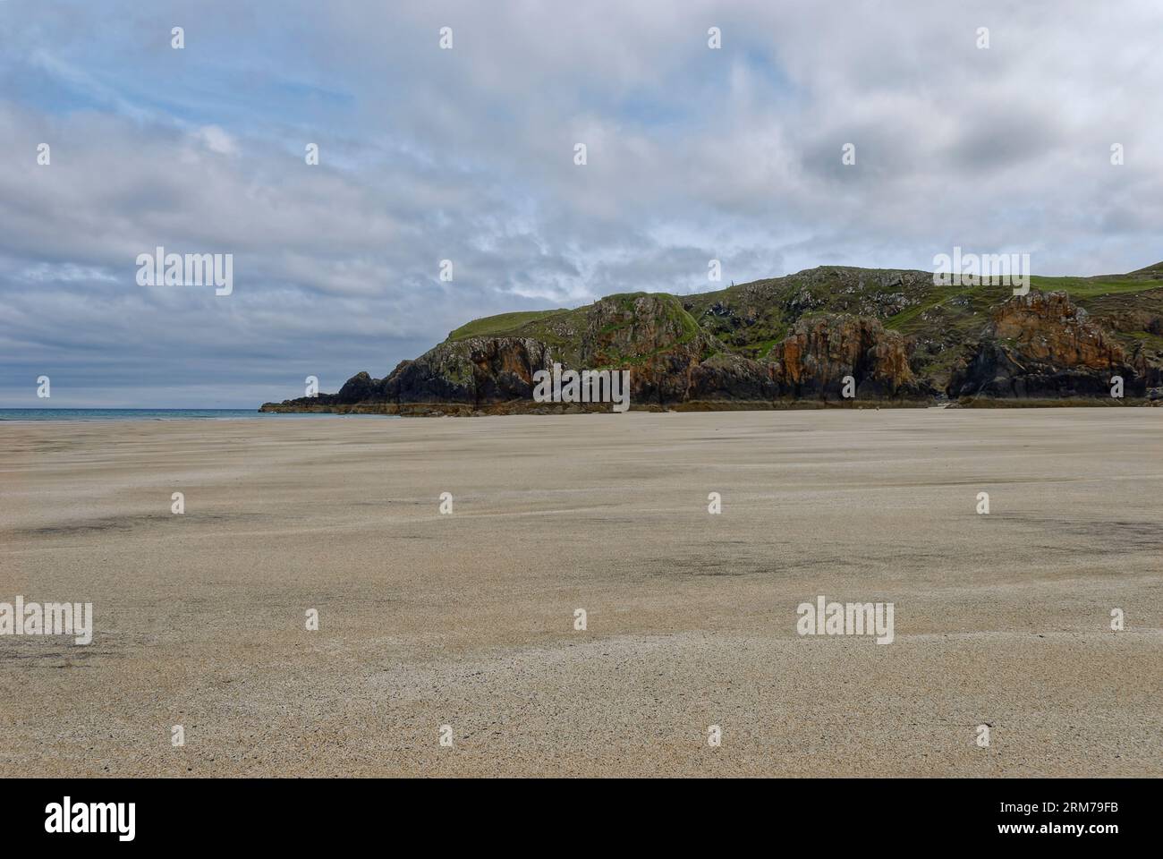 An einem bewölkten Tag im Juni auf der Isle of Lewis in südlicher Richtung zur Landzunge an einem Ende des Garry Beach, mit den Felsvorsprüngen, die auf der flachen sa verstreut sind Stockfoto