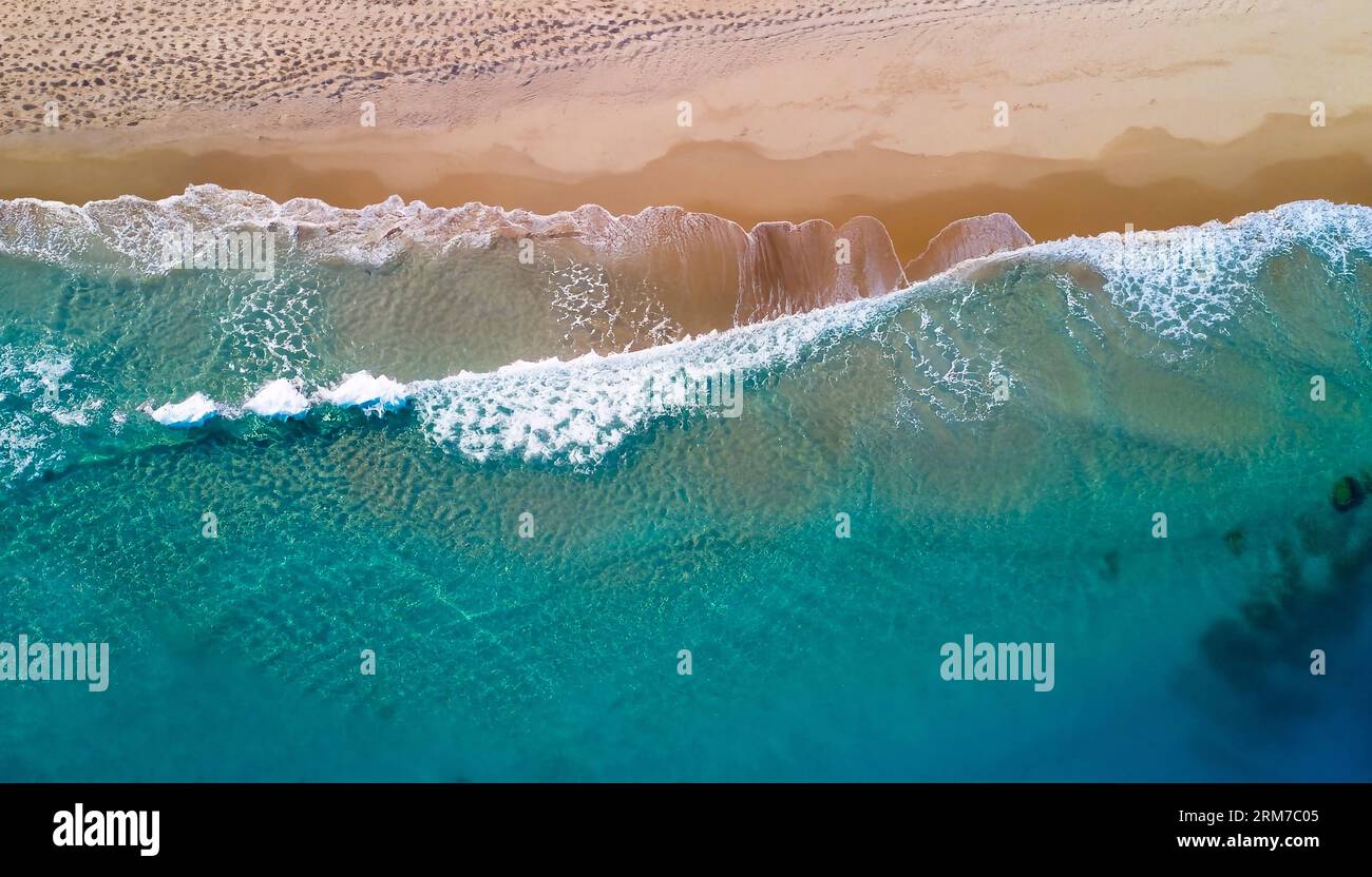 Entspannende Luftaufnahme Strand Szene, Sommerurlaub Urlaub Vorlage Banner. Die Wellen surfen mit der herrlichen blauen Lagune, der Küste und der Küste. Perfekte Antenne Stockfoto
