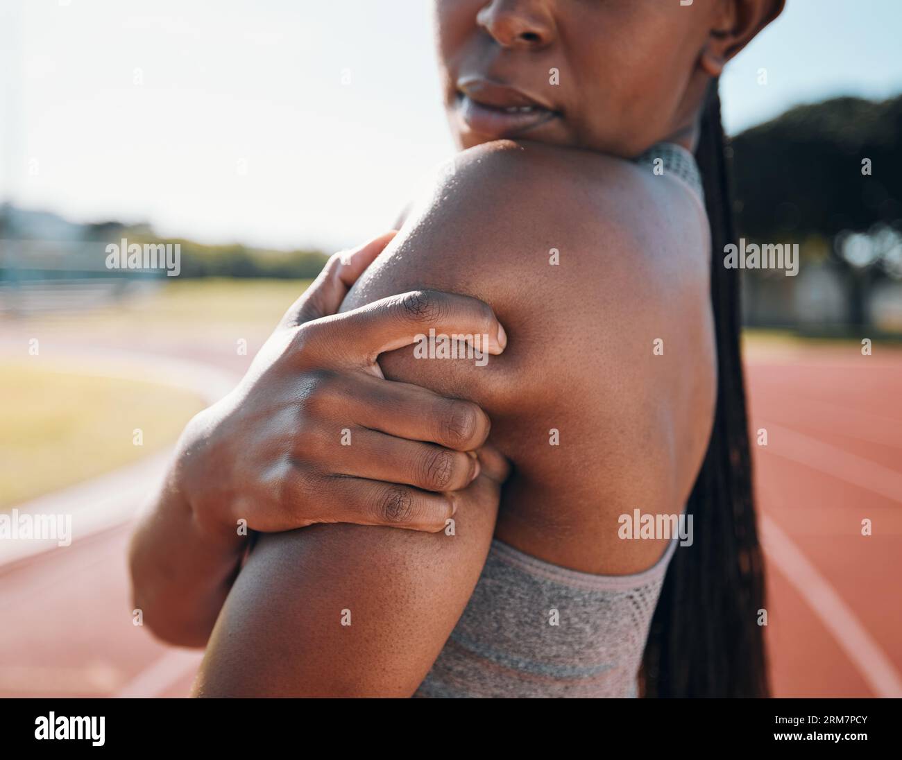 Schulterschmerzen, Fitness und Sportler mit Verletzungsproblem in einem Stadion aufgrund von Outdoor-Übung, Training oder Workout. Verletzung, Entzündung und Person oder Stockfoto