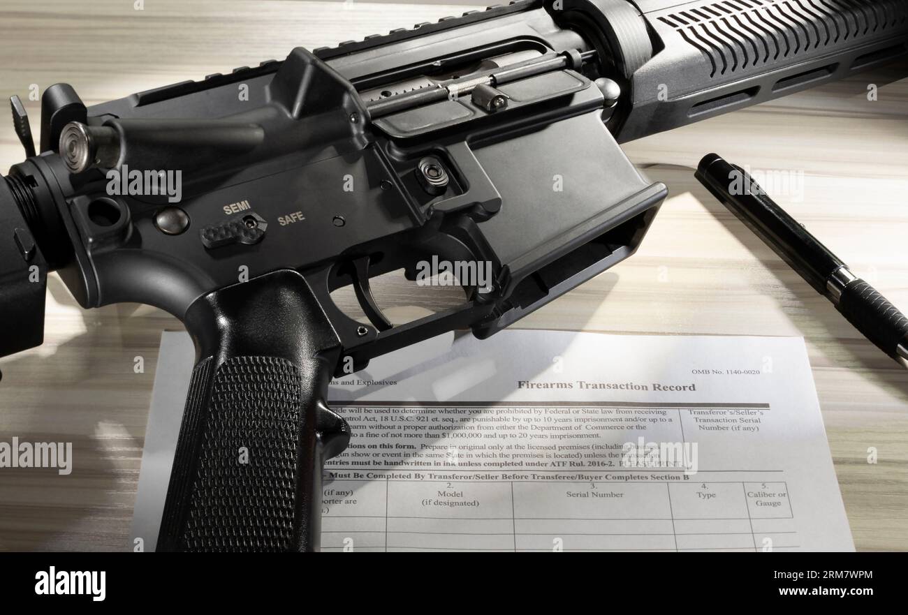 AR-15 mit gemeinfreiem Hintergrundprüfformular und Stift in der Nähe Stockfoto