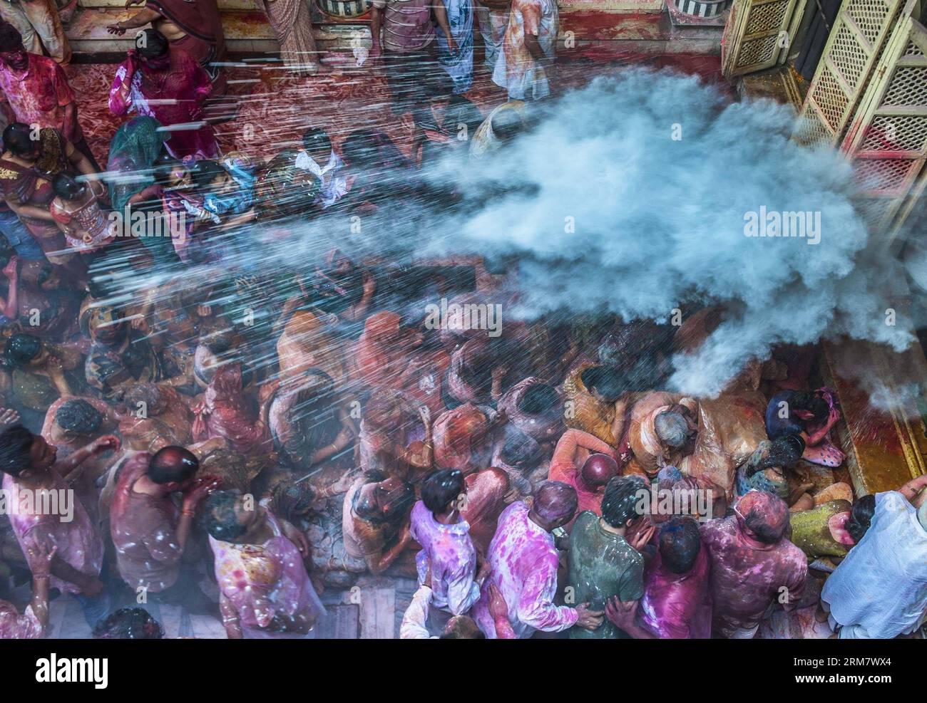 (140317) -- CALCUTTA, 17. März 2014 (Xinhua) -- Indianer streuen Farbpulver auf die Massen in einem Tempel während der Feier des Holi Festivals, auch bekannt als Festival der Farben, in Kalkutta, Hauptstadt des östlichen indischen Bundesstaates Westbengalen, 17. März 2014. Das Holi-Festival ist ein beliebtes Hindu-Frühlingsfest, das in Indien am Ende der Wintersaison am letzten Vollmondtag des Mondmonats stattfindet. (Xinhua/Tumpa Mondal) (srb) INDIA-CALCUTTA-HOLI FESTIVAL PUBLICATIONxNOTxINxCHN Calcutta 17. März 2014 XINHUA indische Prominente streuen Farbpulver AUF DIE Menschenmassen IN einem Tempel während der CEL Stockfoto