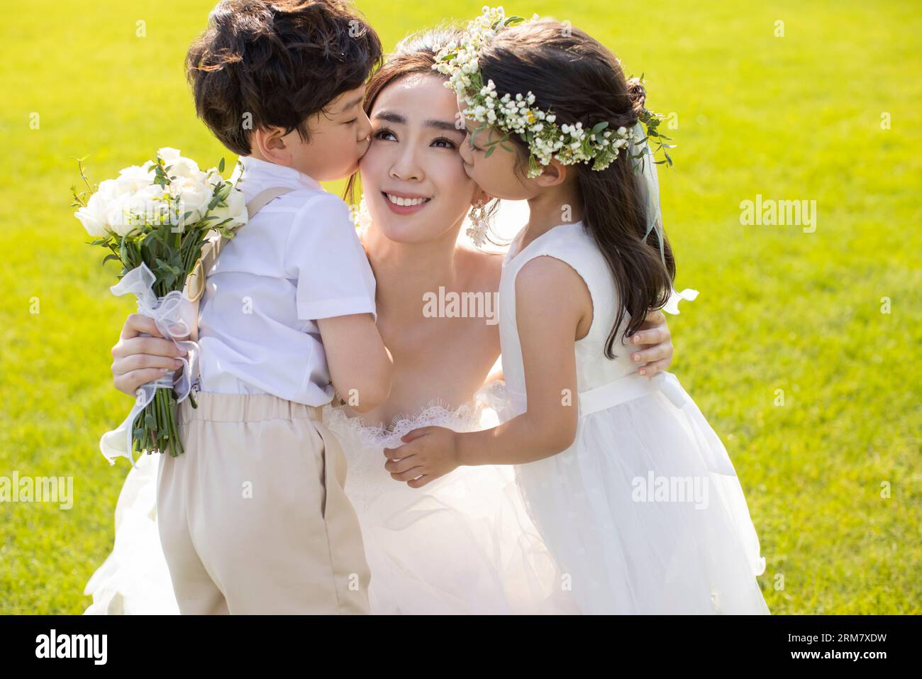 Schöne Braut mit Blumenmädchen und Ringträger Stockfoto