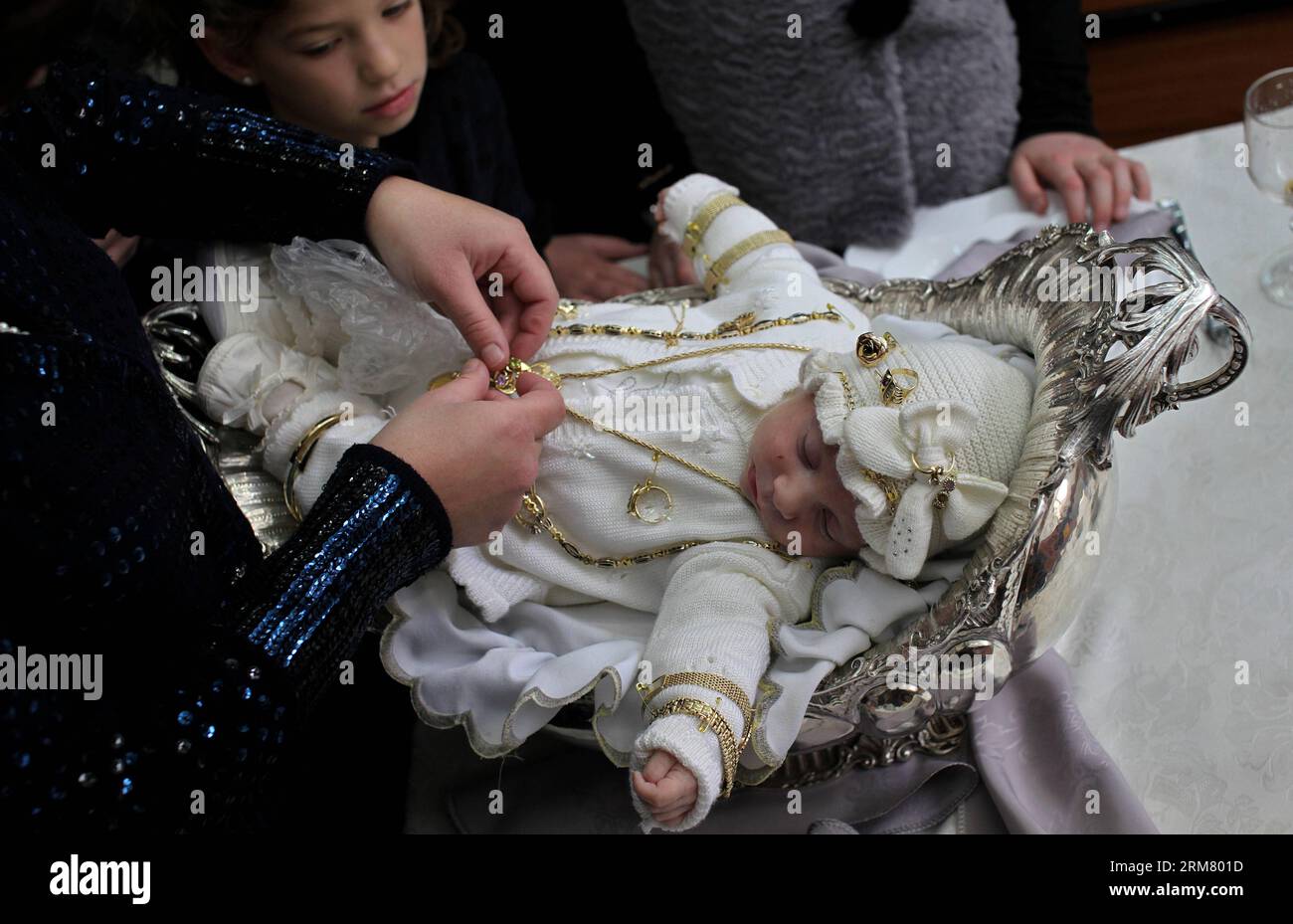 JERUSALEM, 20. März 2014 – das dreißigtägige Kind, Enkel des Rabbiners Eliezer Rozenblum von der chassidischen Schule Nadvorna, wird während seiner Pidyon-Haben-Zeremonie in einer Synagoge in Bnei Brak bei Tel Aviv, Israel, am 20. März 2014 gesehen. Der Pidyon Haben, oder Erlösung des erstgeborenen Sohnes, ist eine Mizwa im Judentum, bei der ein jüdischer Erstgeborener durch die Verwendung von Silbermünzen aus seinem Geburtszustand der Heiligkeit eingelöst wird. Die Erlösung wird erreicht, indem man einem Kohen (einem patrilinearen Nachfahren der Priesterfamilie Aaron) fünf Silbermünzen gibt. Basierend auf den Geboten, die im Gedächtnis der Menschen zu beheben sind, Th Stockfoto