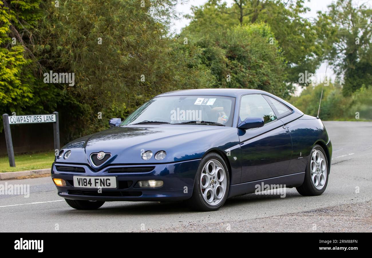 Whittlebury, Northants, UK - 26. August 2023: 1999 blaues Alfa Romeo GTV Auto, das auf einer englischen Landstraße fährt Stockfoto