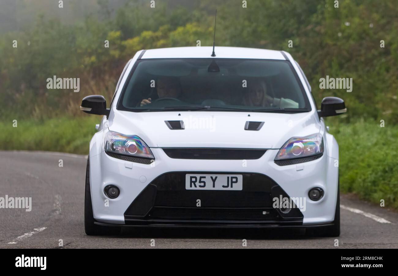 Whittlebury, Northants, UK - 26. August 2023: 2010 weißes Ford Focus RS-Auto, das an einem feuchten und nebligen Morgen auf einer englischen Landstraße fährt. Stockfoto