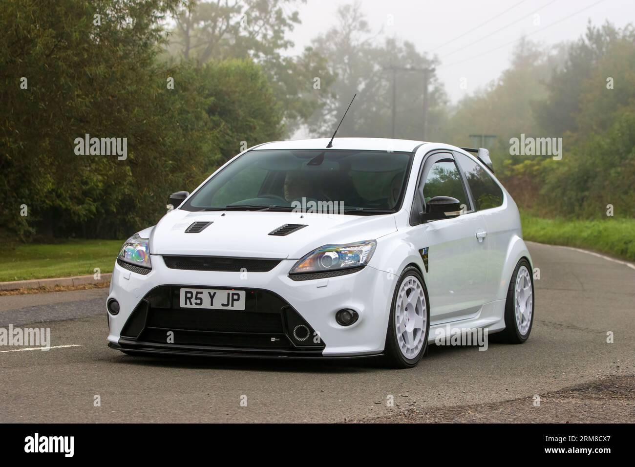 Whittlebury, Northants, UK - 26. August 2023: 2010 weißes Ford Focus RS-Auto, das an einem feuchten und nebligen Morgen auf einer englischen Landstraße fährt. Stockfoto