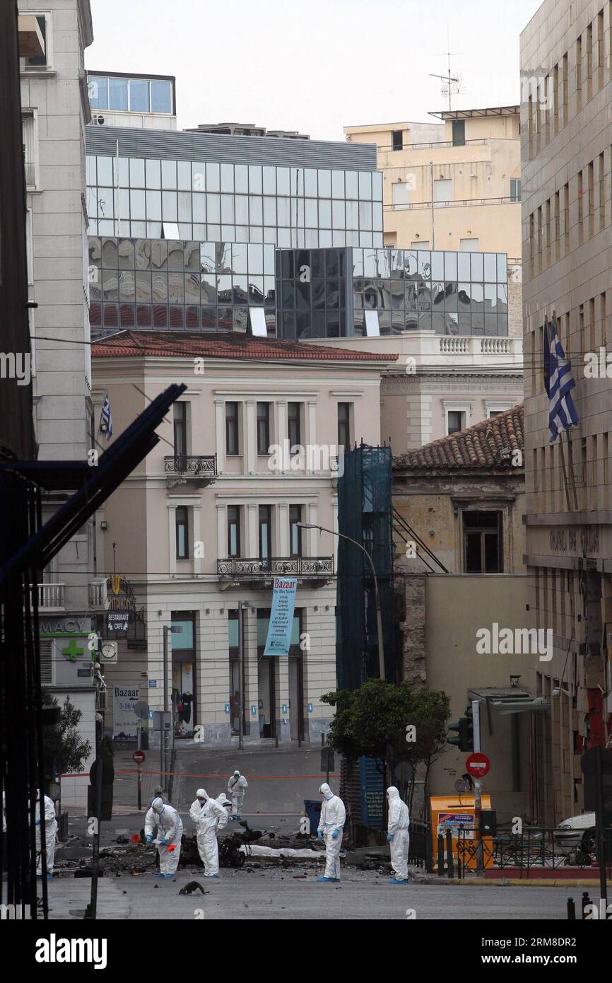 ATHEN, Polizei-Bombenbeseitigungsexperten suchen nach Beweisen in der Nähe von Überresten eines Autos nach einer Autobombenexplosion im Zentrum von Athen, Griechenland, am 10. April 2014. Eine Autobombe explodierte am frühen Donnerstag vor der griechischen Zentralbank im Zentrum von Athen und verursachte Schäden an Büros, Geschäften und Autos in der Nähe. Es wurden keine Verletzungen gemeldet. Der Vorfall ereignete sich zu einer Zeit, als Griechenland am Donnerstag zum ersten Mal seit Beginn der Krise im Jahr 2010 seine Rückkehr an die internationalen Anleihemärkte machen sollte, indem es den Anlegern fünfjährige Anleihen anbot. (Xinhua/Marios Lolos) (lyx) GRIECHENLAND-ATHEN-CAR BOMB-BLAST Stockfoto