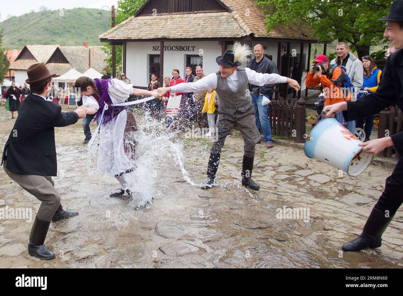 (140421) -- HOLLOKO, 21. April 2014 (Xinhua) -- einheimische Männer spritzen Wasser auf ein Mädchen als Teil der traditionellen Osterfeierlichkeiten in Holloko, einem Dorf in Nordungarn, 21. April 2014. Die Einheimischen aus Holloko, das in die Liste des Weltkulturerbes aufgenommen wurde, feiern Ostern mit der traditionellen Bewässerung der Mädchen, einem Ungarischen Fruchtbarkeitsritual, das in der vorchristlichen Vergangenheit der Region verwurzelt ist. (Xinhua/Attila Volgyi)(zhf) HUNGARY-HOLLOKO-EASTER MONDAY-CELEBRATIONS PUBLICATIONxNOTxINxCHN 21. April 2014 XINHUA Local Men spritzen einem Mädchen Wasser als Teil traditioneller Osterfeiern in einer Vill Stockfoto