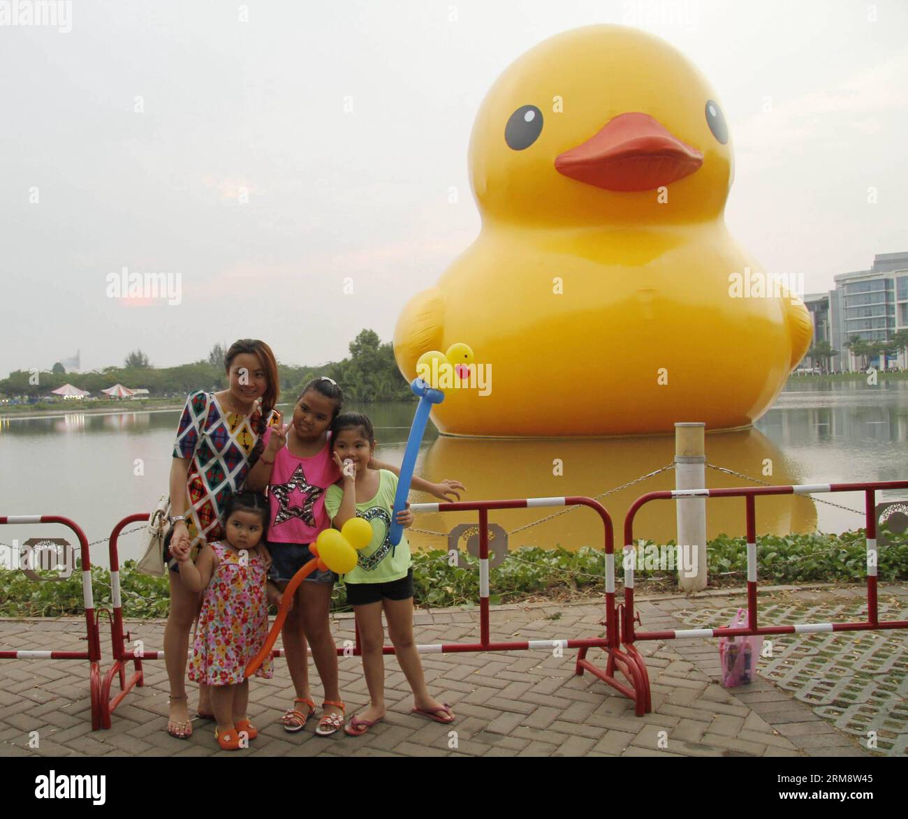 (140427) -- HO CHI MINH STADT, April 26 (Xinhua) -- Menschen posieren für Fotos mit der riesigen Gummiente in der Phu My Hung Wohngegend in Ho Chi Minh (HCM) Stadt, Vietnam, 26. April 2014. Eine 18 Meter hohe Gummiente, die Menschen auf der ganzen Welt in ihren Bann gezogen hat, wird am Crescent Lake im Wohngebiet Phu My Hung der HCM-Stadt von April 27 bis Mai 31 ausgestellt, berichteten lokale Medien am Samstag. Die Gummiente wurde vom niederländischen Künstler Florentijn Hofman entworfen und startete 2007 eine Tour mit dem Namen Spread Joys Around the World. HCM City ist der 16. Veranstaltungsort, an dem es angezeigt wird. (Xinhua/Tao Jun) Stockfoto