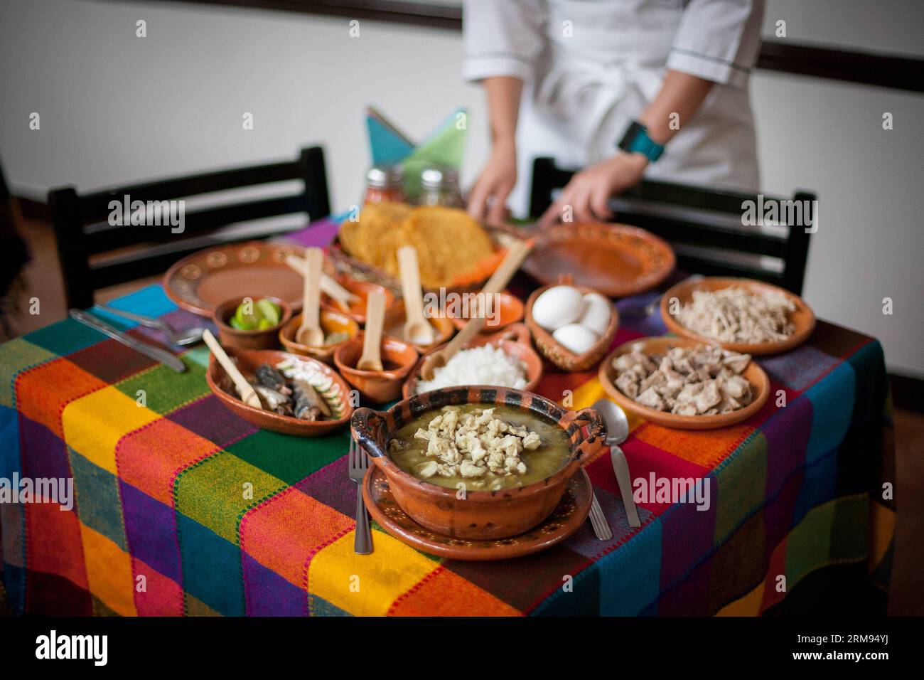 (140507) -- MEXIKO-STADT, 7. Mai 2014 (Xinhua) -- Eine Frau bereitet Eine Portion Pozole (Maissuppe) im Pozoleria Tixtla Restaurant in Mexiko-STADT, Hauptstadt von Mexiko, am 7. Mai 2014 zu. Das Pozole ist ein traditionelles Gericht, das unter anderem in den bundesstaaten Guerrero, Michoacan, Jalisco, Nayarit und Sinaloa zubereitet wird. Der Ursprung geht auf die vorhispanische Zeit zurück. Unter den verschiedenen Rezepten für die Zubereitung von Pozole hat der Guerrero-Staat die Besonderheit, grün zu sein, da er mit einer Mischung aus traditioneller Maulwurfsauce grüner Farbe, Chicharron (Schweineschleife), Sardine und rohem Ei zubereitet wird (Xinhua/Pedro) Stockfoto