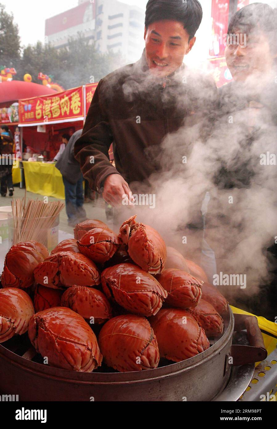 (140513) -- PEKING, 13. Mai 2014 (Xinhua) -- Foto aufgenommen am 18. November 2006 zeigt Menschen, die gedämpfte Krabben auf einem taiwanesischen Lebensmittelfestival in Zhengzhou, der Hauptstadt der zentralchinesischen Provinz Henan, beobachten. Eine der beliebtesten Arten weltweit, chinesische Küche ist berühmt für ihren Geschmack und ihre Vielfalt, mit einer beispiellosen Auswahl an Zutaten, Techniken, Gerichten und Essstilen. Die Geschichte der chinesischen Küche reicht seit Tausenden von Jahren zurück und hat sich von Periode zu Periode und in jeder Region je nach Klima, Tradition und lokalen Präferenzen verändert. Die Chinesen sind stolz darauf, eine breite Vielfalt zu essen Stockfoto