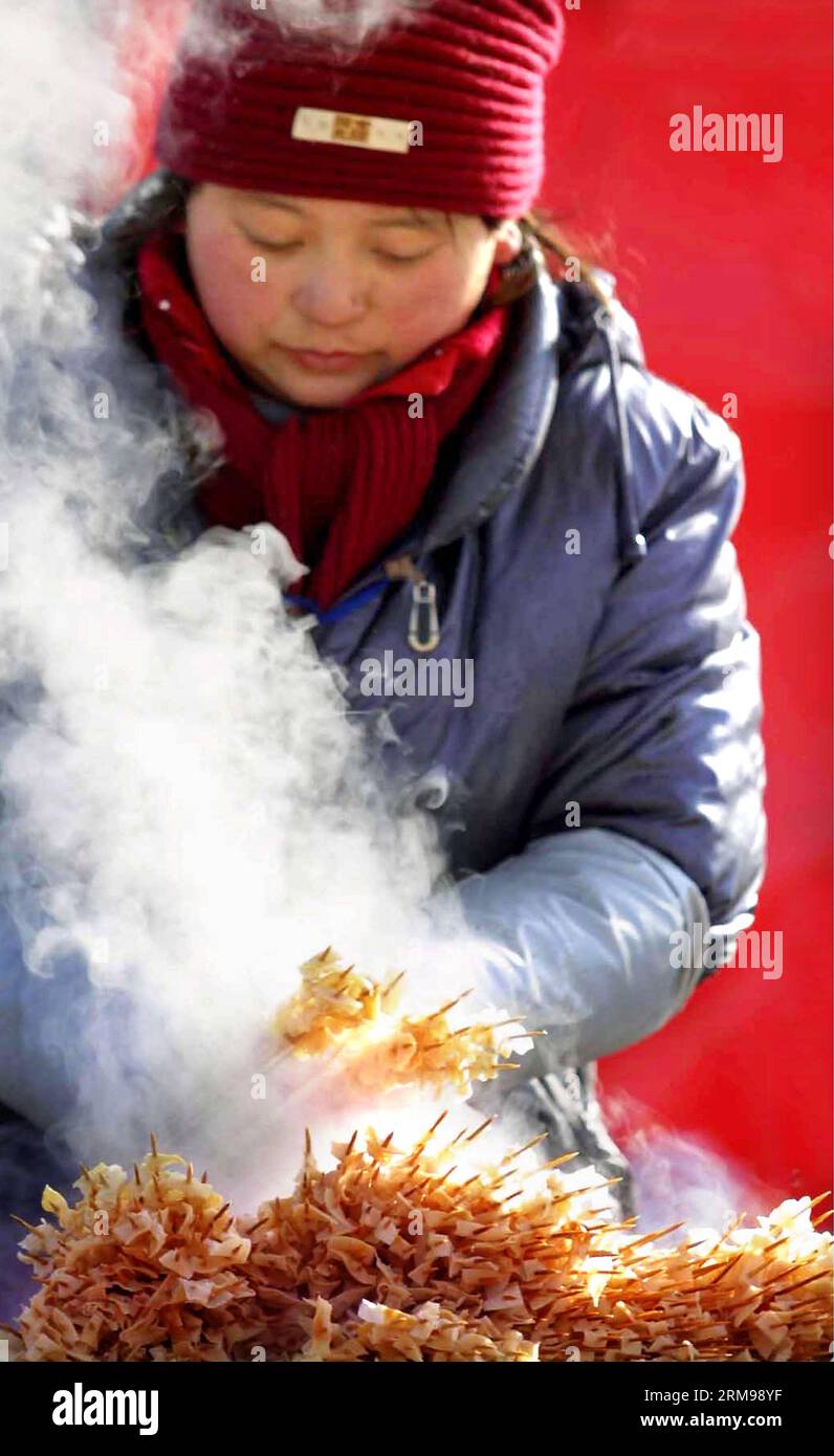 (140513) -- PEKING, 13. Mai 2014 (Xinhua) -- Foto vom 18. Februar 2005 zeigt eine Frau, die in Zhengzhou, der Hauptstadt der zentralchinesischen Provinz Henan, Grillgerichte verkauft. Eine der beliebtesten Arten weltweit, chinesische Küche ist berühmt für ihren Geschmack und ihre Vielfalt, mit einer beispiellosen Auswahl an Zutaten, Techniken, Gerichten und Essstilen. Die Geschichte der chinesischen Küche reicht seit Tausenden von Jahren zurück und hat sich von Periode zu Periode und in jeder Region je nach Klima, Tradition und lokalen Präferenzen verändert. Die Chinesen sind stolz darauf, eine große Vielfalt an Lebensmitteln zu essen und dabei zu bleiben Stockfoto