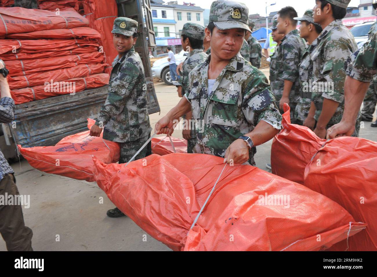 (140524) -- KUNMING, 24. Mai 2014 (Xinhua) -- Rettungskräfte tragen Planen für die betroffenen Menschen nach einem Erdbeben in der Provinz Yingjiang in Dehong Dai und der autonomen Präfektur Jingpo, Provinz Yunnan im Südwesten Chinas, 24. Mai 2014. Ein Erdbeben der Stärke 5,6 erschütterte das Yingjiang County um 4:49 Uhr Samstag (Beijing Time), so das China Earthquake Networks Center. 13 Menschen sind seit 14 Uhr verletzt worden. Ermittlungen und Katastrophenhilfe in der Nähe des Epizentrums wurden durchgeführt. (Xinhua/Chen Haining) (yxb) CHINA-YUNNAN-YINGJIANG-EARTHQUAKE (CN) PUBLICATIONxNOTxINxCHN Kunming Stockfoto