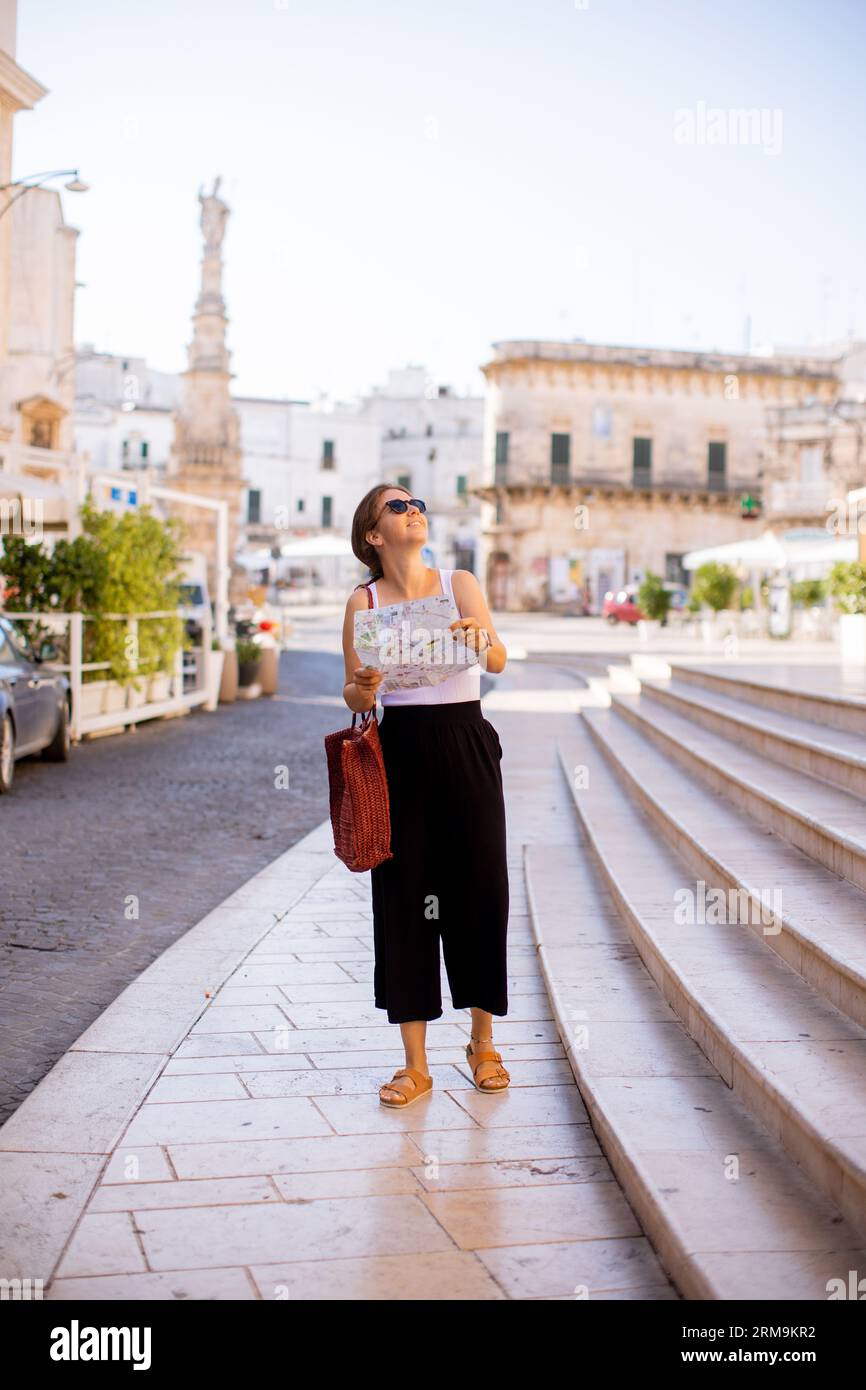 Weibliche Touristen mit einem Stadtplan von der Statue des Heiligen Oronzo in Ostuni, Italien Stockfoto