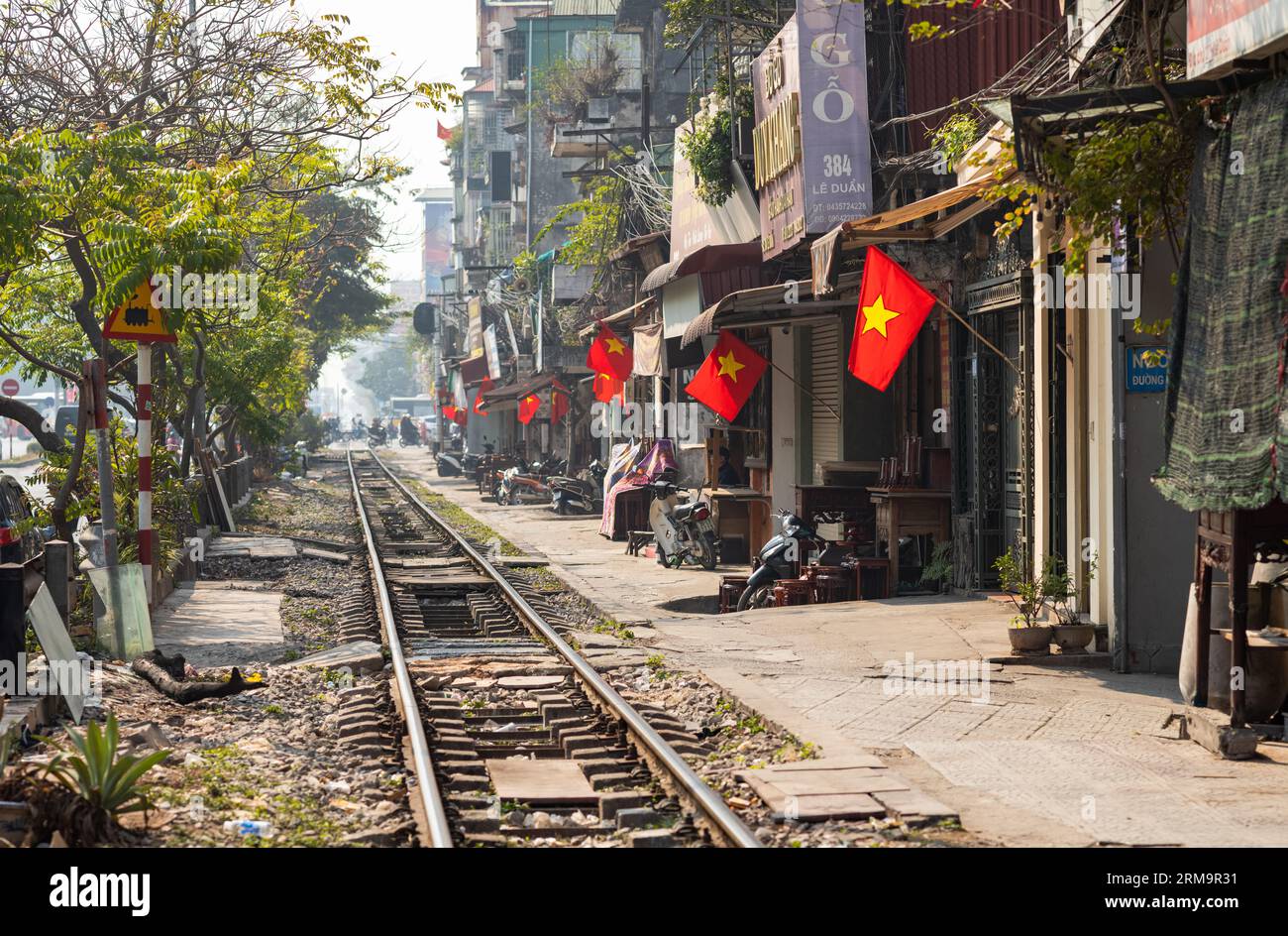 Vietnamesische Flaggen fliegen im verschmutzten Smog entlang der Nord-Süd-Hauptbahn, die Hanoi und Ho-Chi-Minh-Stadt verbindet, während sie L passiert Stockfoto