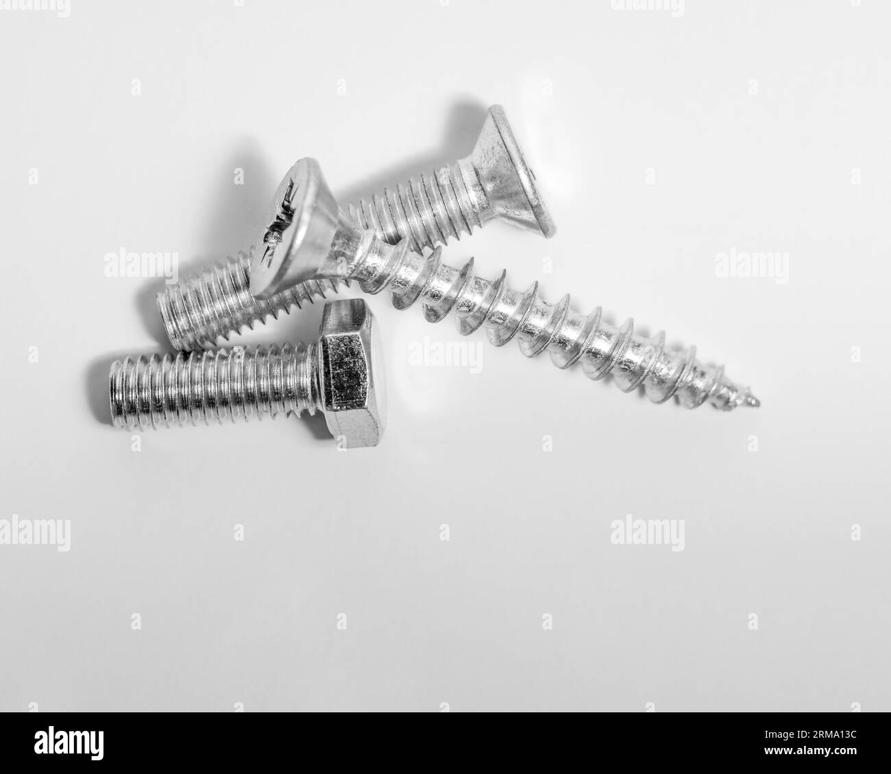 Schrauben, Schrauben liegen auf einer Metalloberfläche Stockfoto