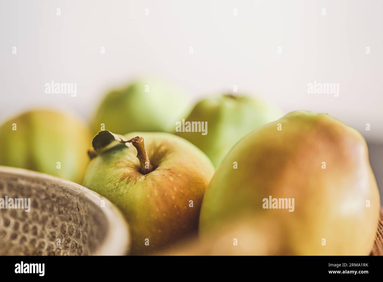 Selektiver Fokus auf grüne Äpfel auf dem Tisch, verschwommener undeutlicher Hintergrund, Ernte, Hintergrundidee Stockfoto