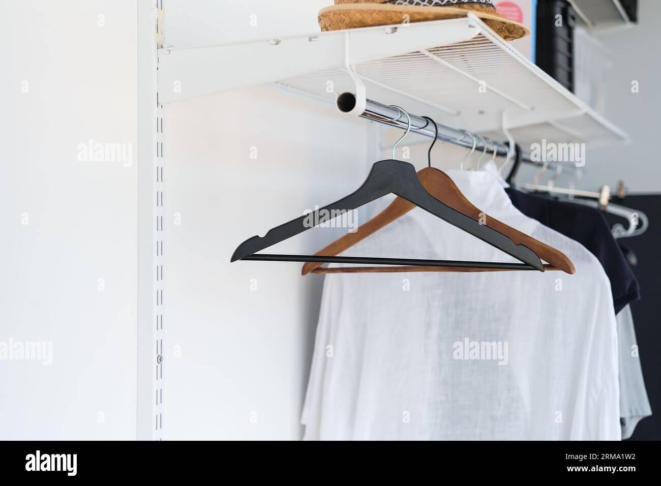 Leere Kleiderbügel an einem Kleiderbügel im Schrank, Idee für einen Hintergrund oder Werbung für einen Verkauf. Selektiver Fokus Stockfoto