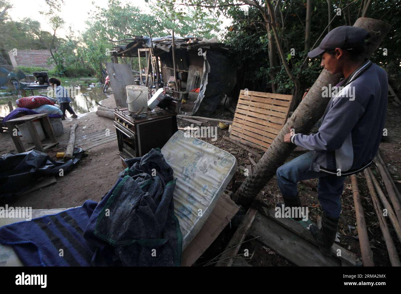 BARRANQUERAS, 12. Juni 2014 (Xinhua) -- Ein Bewohner trägt Baumstämme in der Ortschaft Barranqueras in der Provinz Chaco, Argentinien, 12. Juni 2014. Die Provinzen Chaco, Corrietnes, Santa Fe und Entre Rios waren am Donnerstag von Überschwemmungen in den Ufergebieten betroffen. (Xinhua/German Pomar/TELAM) ARGENTINA-BARRANQUERAS-ENVIRONMENT-FLOOD PUBLICATIONxNOTxINxCHN 12. Juni 2014 XINHUA A-Bewohner trägt in der Ortschaft Chaco Province Argentina 12. Juni 2014 die Provinzen Chaco Santa Fe und Entre Rios waren am Donnerstag von Überschwemmungen in den Riparian Zones XAM Argentina ENINHUA betroffen Stockfoto