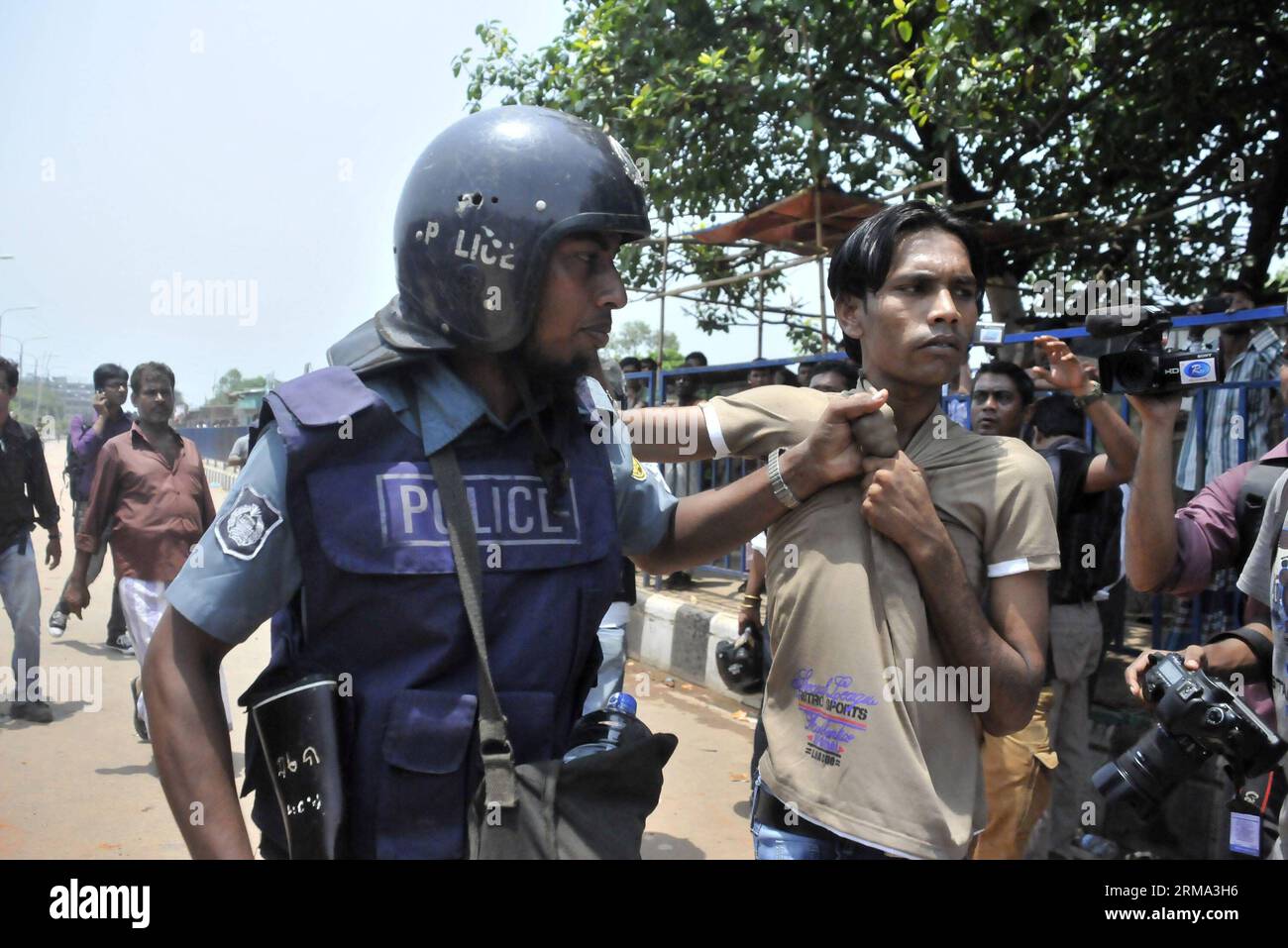 (140614) -- DHAKA, 14. Juni 2014 (Xinhua) -- Ein Polizist verhaftet einen Flüchtling während eines Zusammenstoßes in einem Flüchtlingscamp in Dhaka, Bangladesch, 14. Juni 2014. Mindestens neun Menschen, darunter drei Kinder und zwei Frauen, wurden bei einem verheerenden Brand während einer Reihe gewalttätiger und chaotischer Zusammenstöße in einem Flüchtlingslager von Biharis oder gestrandeten Pakistanis in Bangladeschs Hauptstadt Dhaka am Samstagmorgen verbrannt. (Xinhua/Shariful Islam) BANGLADESCH-DHAKA-FIRE-REFUGEE PUBLICATIONxNOTxINxCHN DHAKA 14. Juni 2014 XINHUA ein Polizist verhaftet einen FLÜCHTLING während eines Kampfes in einem Flüchtlingslager in Dhaka Bangladesch 14. Juni 2014 UM Stockfoto