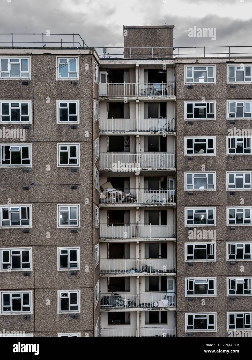 Hintergrund der Architektur eines verlassenen Turmblocks aus den 1960er Jahren mit Reihen von kaputten Fenstern und Balkonen in einem Teil der Innenstadt, der r braucht Stockfoto