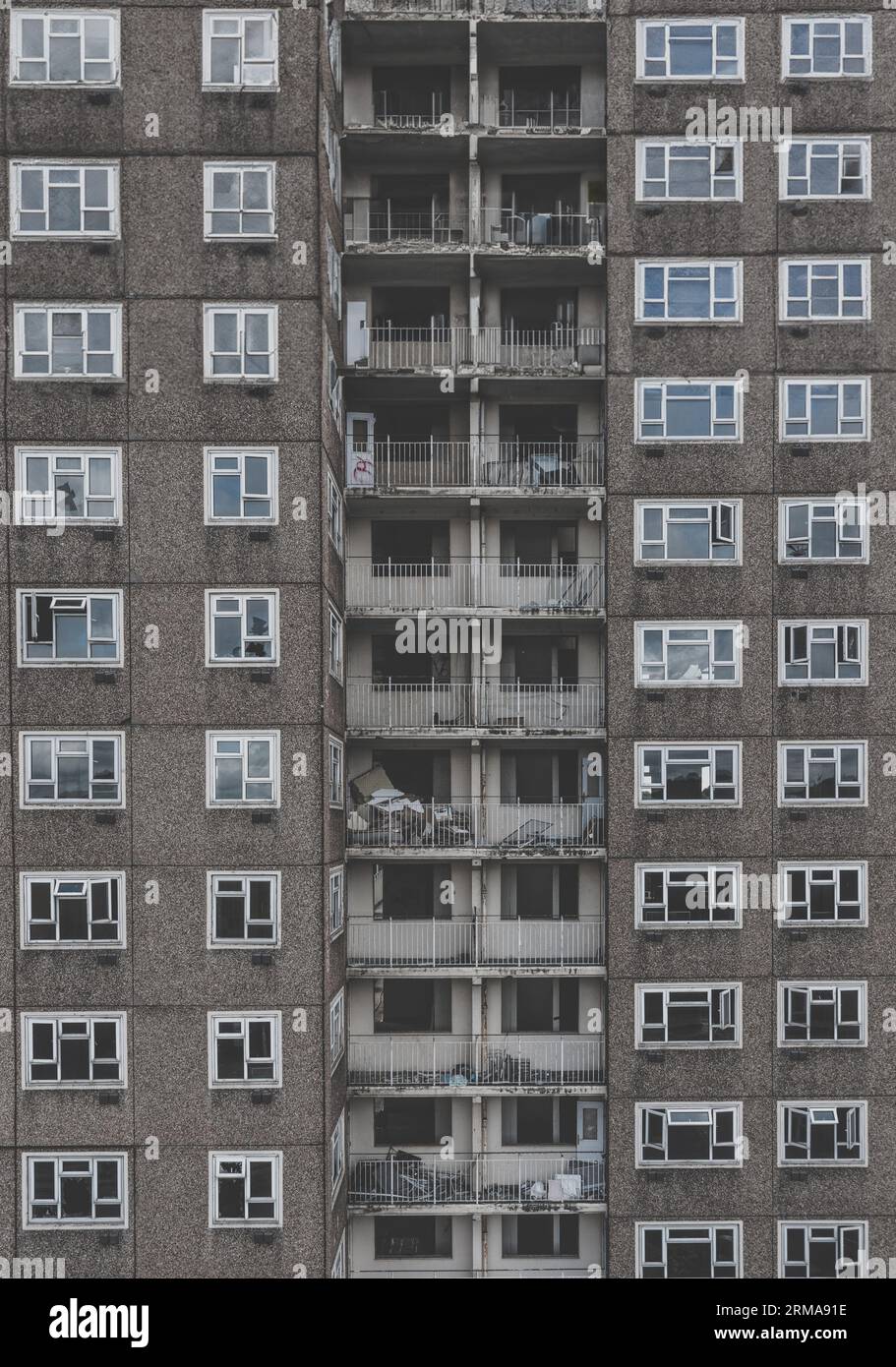 Hintergrund der Architektur eines verlassenen Turmblocks aus den 1960er Jahren mit Reihen von kaputten Fenstern und Balkonen in einem Teil der Innenstadt, der r braucht Stockfoto