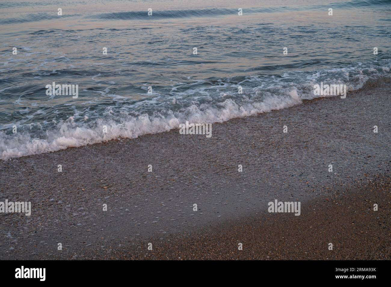 Wellen des Mittelmeers, die sich zum türkischen Sandstrand hin bewegen. Schöner türkischer Abend. Stockfoto