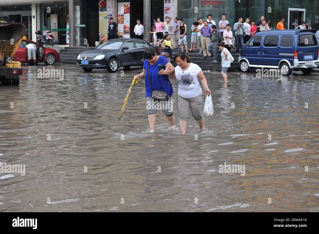 (140704) -- TAIYUAN, 4. Juli 2014 (Xinhua) -- Bürger gehen auf einer überfluteten Straße in Taiyuan, der Hauptstadt der nordchinesischen Provinz Shanxi, 4. Juli 2014. Am Freitag überfluteten Regenfälle die Straßen und verursachten Verkehrsunterbrechungen. (Xinhua/Zhan Yan) (mp) CHINA-SHANXI-TAIYUAN-RAININSTORM-FLOODS (CN) PUBLICATIONXNOTXINXCHN Taiyuan 4. Juli 2014 XINHUA-Bürger gehen AUF einer überfluteten Straße in Taiyuan Hauptstadt von Nordchina S Shanxi Provinz 4. Juli 2014 Regenfälle trafen die Stadt AM Freitag, überschwemmten Straßen und verursachten Verkehrsunterbrechungen XINHUA Zrainstoran China Shani MP Taiyuan YKN Stockfoto