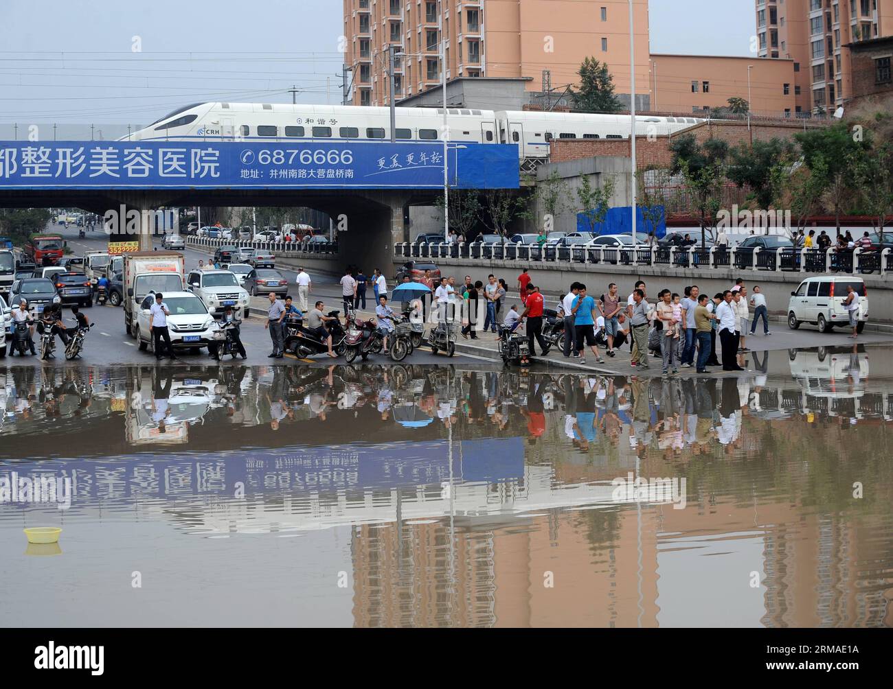 (140704) -- TAIYUAN, 4. Juli 2014 (Xinhua) -- Fahrzeuge und Fußgänger halten vor einem wasserdurchfluteten Abschnitt auf einer Straße in Taiyuan, der Hauptstadt der nordchinesischen Provinz Shanxi, am 4. Juli 2014. Am Freitag überfluteten Regenfälle die Straßen und verursachten Verkehrsunterbrechungen. (Xinhua/Yan Yan) (MP) CHINA-SHANXI-TAIYUAN-RAININSTORM-FLOODS (CN) PUBLICATIONxNOTxINxCHN TAIYUAN 4. Juli 2014 XINHUA FAHRZEUGE und Fußgänger halten vor einem wasserdurchfluteten Abschnitt AUF einer Straße in Taiyuan Hauptstadt VON Nordchina S Shanxi Provinz Juli 2014 Regenfälle in der Stadt AM Freitag Überschwemmungen Stockfoto