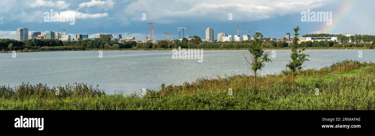 Ouderkerk aan de Amstel, Niederlande, 26.08.2023, Panoramablick auf die Skyline von Amsterdam Zuidoost vom See Ouderkerkerplas aus Stockfoto
