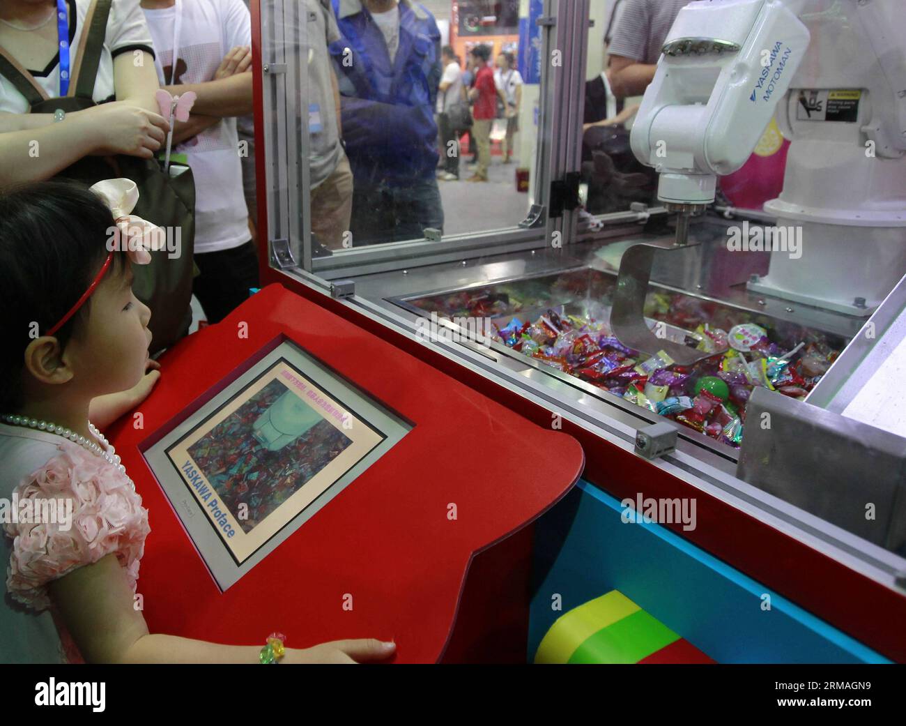 (140709) -- SHANGHAI, 9. Juli 2014 (Xinhua) -- Ein Mädchen spielt eine Preiskralle für Süßigkeiten während der China International Robot Show im ostchinesischen Shanghai, 9. Juli 2014. Die dreitägige Show startete am Mittwoch und zeigte die neuesten Erfolge in der Roboterindustrie. (Xinhua/Ding Ting) (mp) CHINA-SHANGHAI-ROBOT SHOW (CN) PUBLICATIONxNOTxINxCHN Shanghai 9. Juli 2014 XINHUA A Girl PLAYS a Prize Claw for Candies während der China International Robot Show in East China S Shanghai 9. Juli 2014 die dreitägige Show startete AM Mittwoch und zeigte die neuesten Errungenschaften in der Roboterindustrie XINHUA T Stockfoto