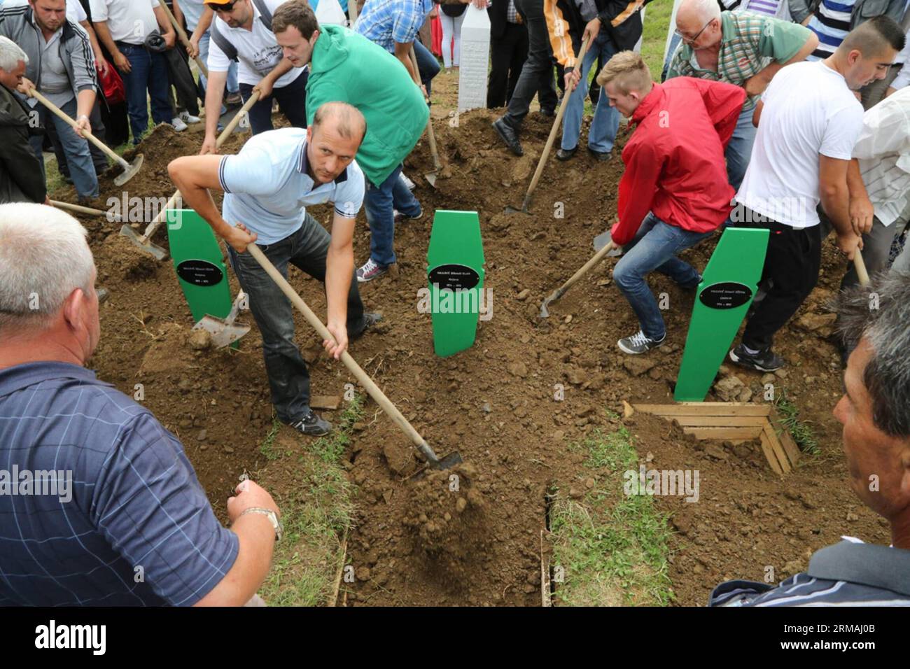 Die Menschen begraben die Särge eines Mannes und seiner beiden Söhne während einer Beerdigung in Potocari, bei Srebrenica, Bosnien und Herzegowina, am 11. Juli 2014. Die Beerdigung von 175 kürzlich identifizierten Opfern fand hier am Freitag zum Gedenken an den 19. Jahrestag des Massakers von Srebrenica statt. Etwa 7.000 muslimische Männer und Jungen wurden im Juli 1995 von bosnischen serbischen Truppen in Srebrenica und in der Nähe von Srebrenica massakriert, das schlimmste Massaker in Europa seit dem Ende des Zweiten Weltkriegs (Xinhua/Haris Memija) (zjl) BIH-SREBRENICA-MASSACRE-19th ANIVERSARY PUBLICATIONxNOTxINxCHN Prominente begraben Coffin of a man and his two Sons während einer Beerdigung in Near S Stockfoto