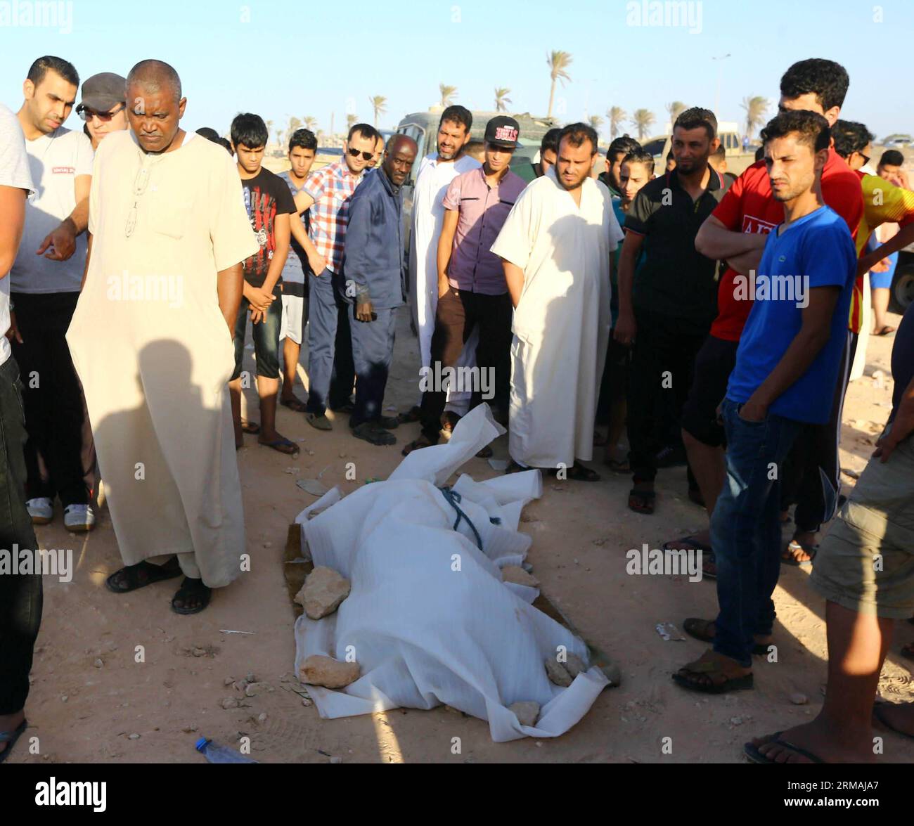 Die Einheimischen beobachten am 12. Juli 2014 einen Körper eines illegalen Einwanderers an der Küste in der Nähe von Tripoli, Libyen. Insgesamt 12 Leichen illegaler Einwanderer wurden vor den Küsten in der Nähe der libyschen Hauptstadt Tripoli gefunden, berichtete die offizielle Agentur LANA am Samstag. (Xinhua/Hamza Turkia) LIBYEN-TRIPOLI-ILLEGALE EINWANDERER-TOD PUBLICATIONxNOTxINxCHN Lokale Prominente beobachten eine Leiche von illegalen Einwanderern an der Küste in der Nähe von Tripoli Libyen AM 12. Juli 2014 wurden insgesamt 12 Leichen illegaler Einwanderer vor den Küsten in der Nähe der libyschen Hauptstadt Tripoli gefunden die offizielle Lana-Agentur berichtete AM Samstag XINHUA Hamza Stockfoto
