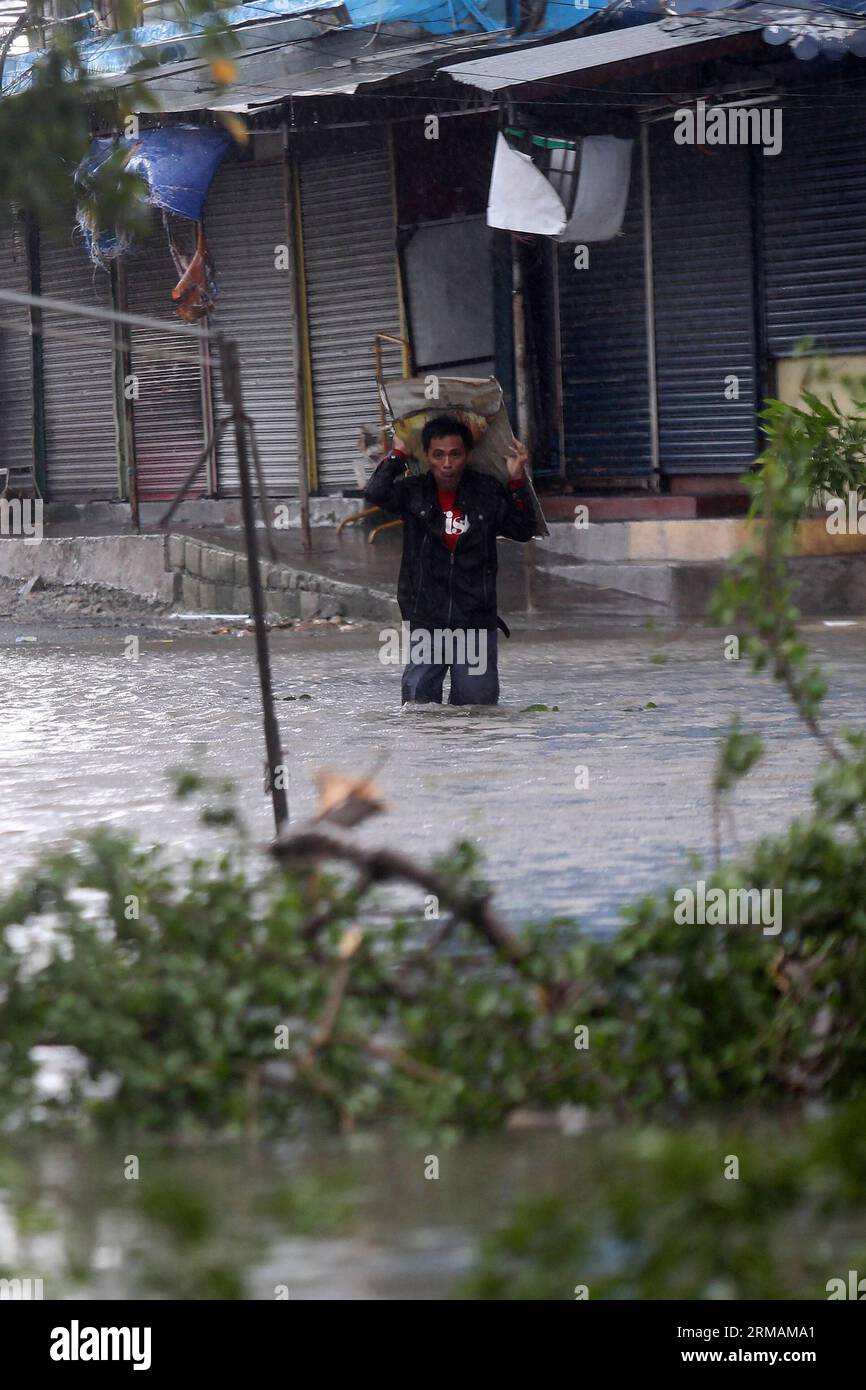 (140716) -- PROVINZ CAVITE, 16. Juli 2014 (Xinhua) -- Ein Mann waten auf Flutkatastrophe durch den Taifun Rammasun in der Provinz Cavite, Philippinen, 16. Juli 2014. Mindestens 5 Menschen wurden getötet, nachdem der Taifun Rammasun (lokaler Name: Glenda) am Mittwoch die philippinische Hauptstadt Metro Manila lahmlegte. (Xinhua/Rouelle Umali) PHILIPPINEN-CAVITE PROVINZ-TAIFUN RAMMASUN PUBLICATIONxNOTxINxCHN Provinz Cavite 16. Juli 2014 XINHUA ein Mann Wade ON Flood GEBRACHT von Taifun in Provinz Cavite die Philippinen 16. Juli 2014 mindestens 5 Prominente wurden nach dem Ansturm von T GETÖTET Stockfoto